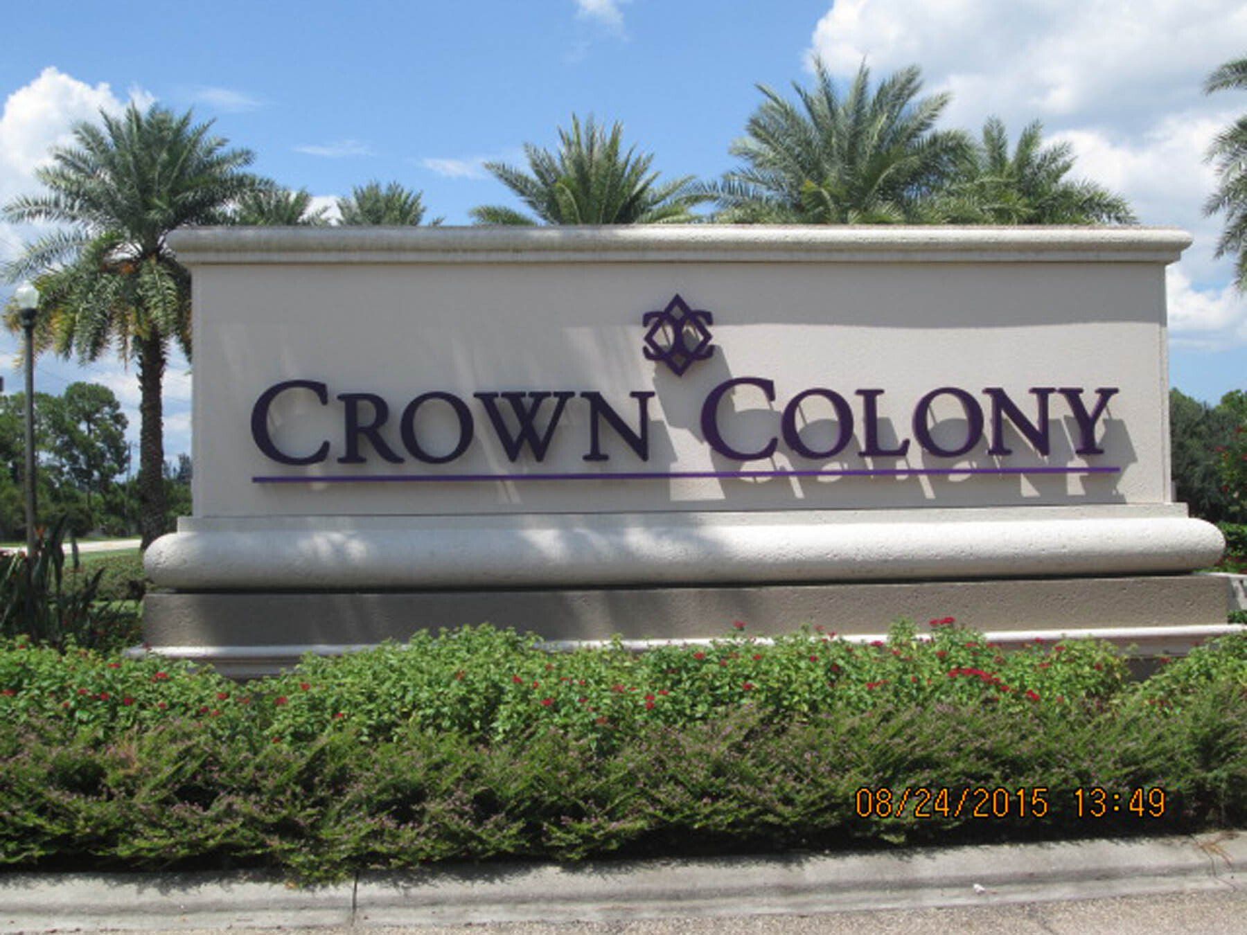 A crown colony sign with palm trees in the background
