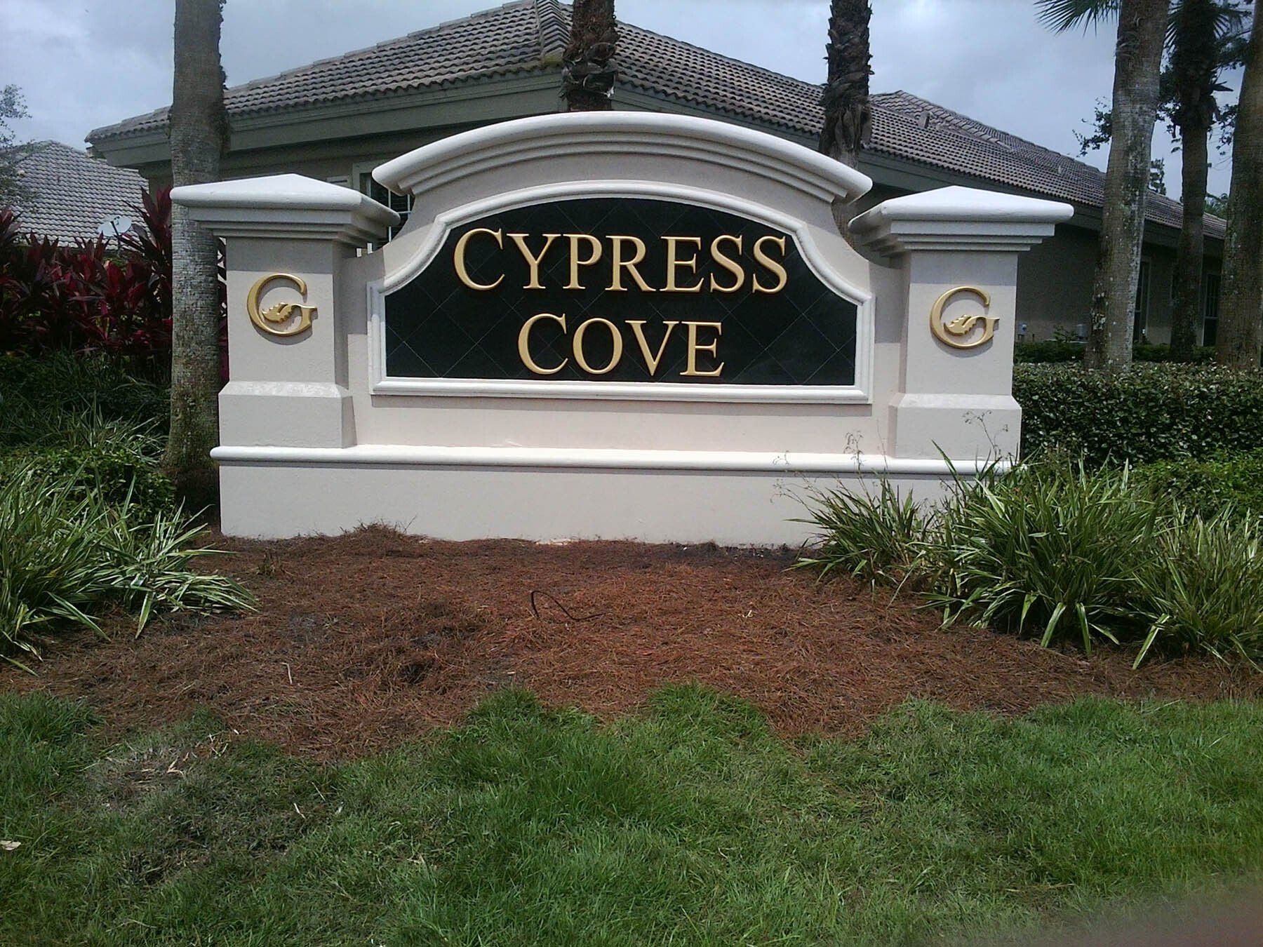 A sign that says cypress cove in front of a house