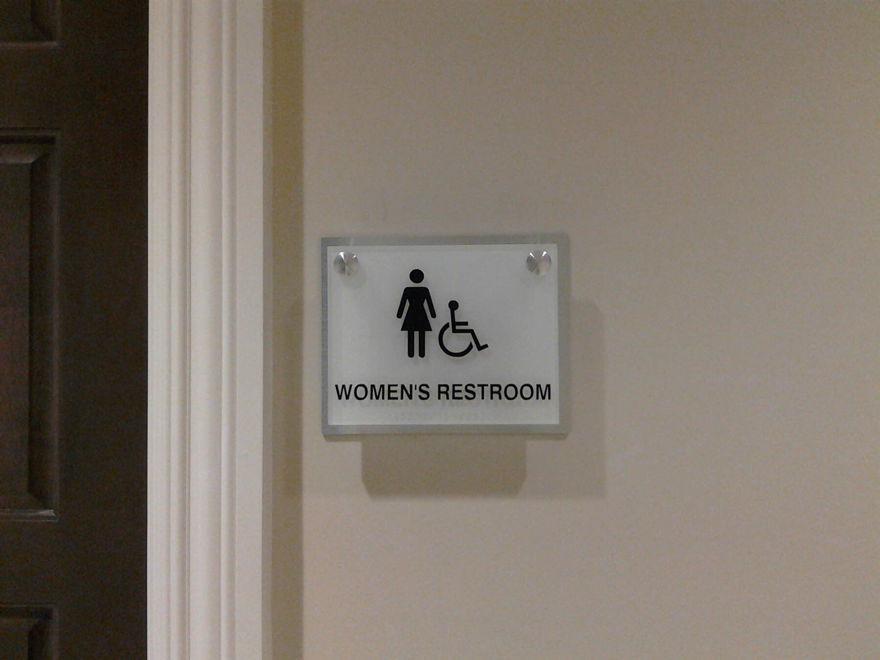 A sign on a wall that says women 's restroom