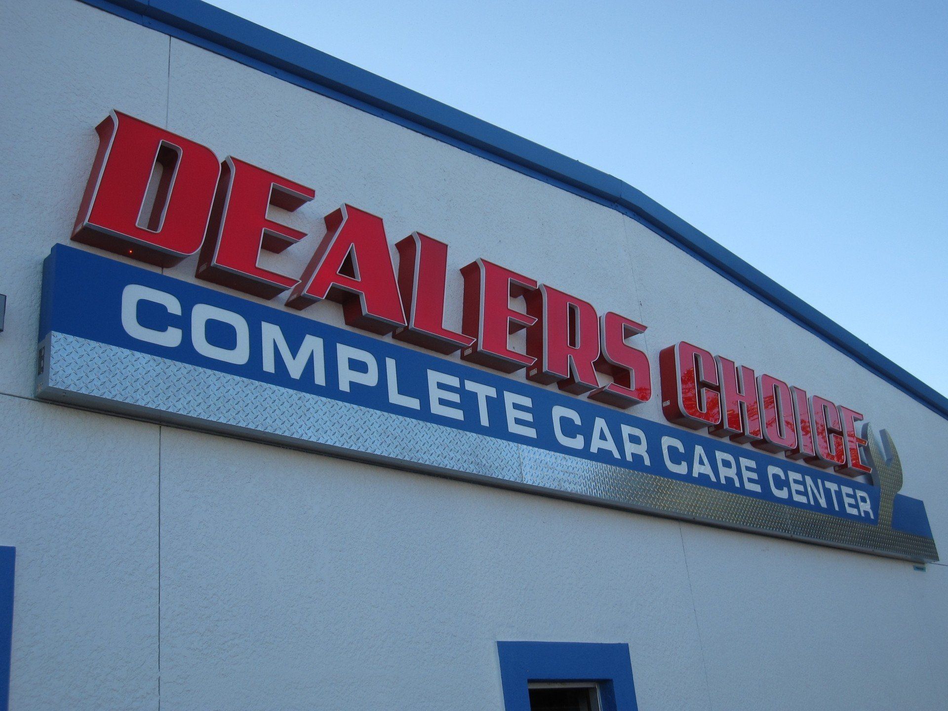 A sign on the side of a building that says dealers complete car care center