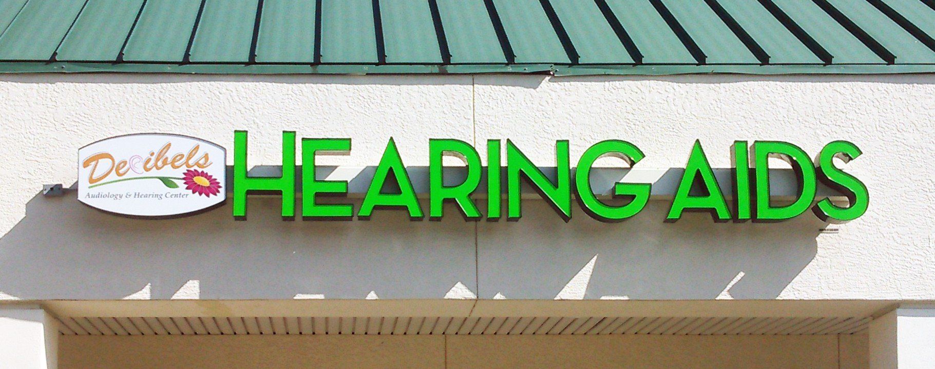 A green sign that says hearing aids on it