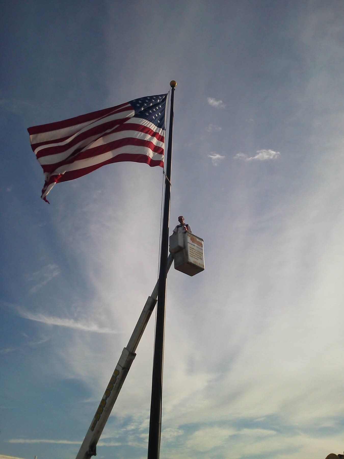 An american flag is flying in the wind on a pole