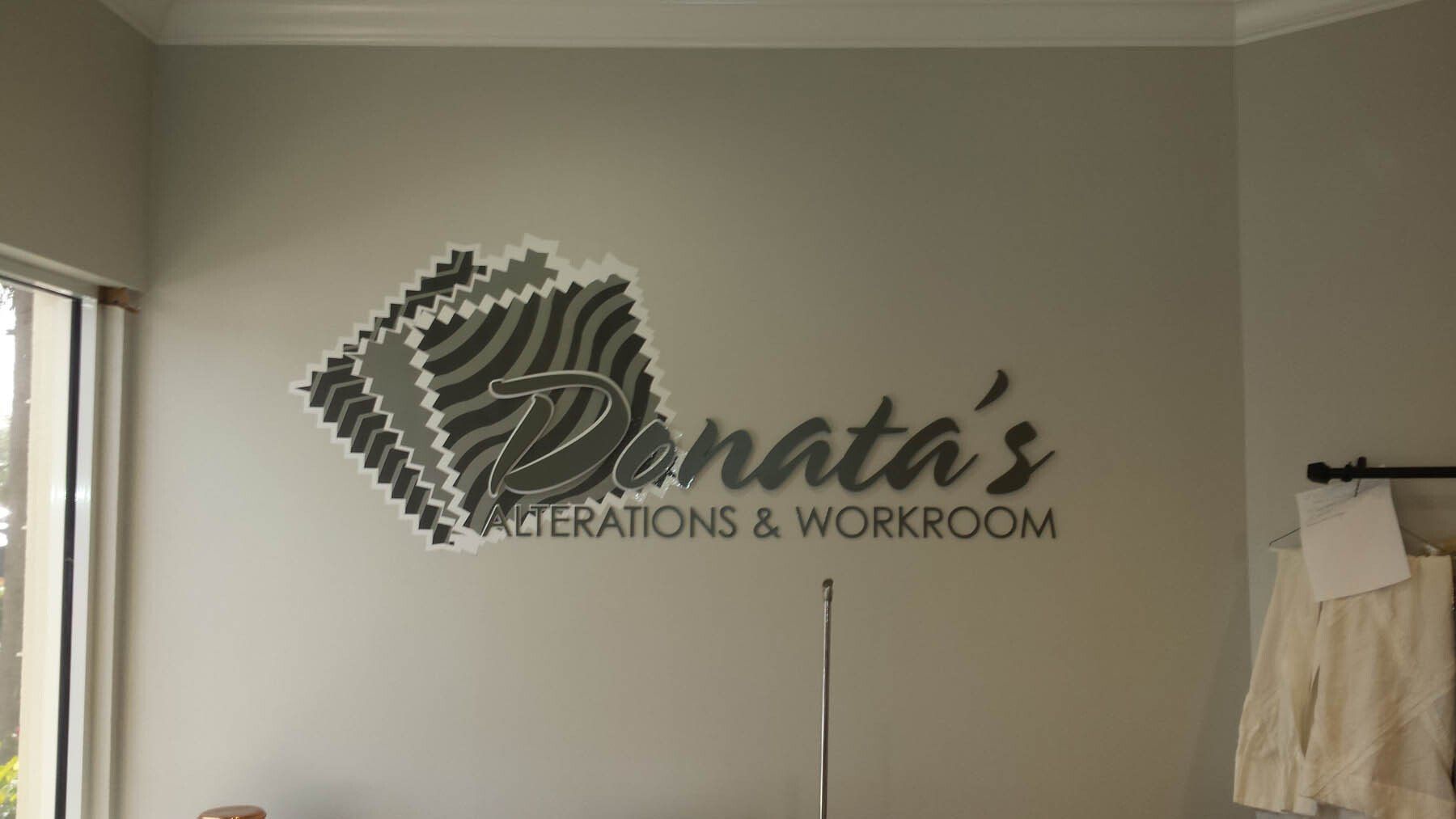 A wall with a logo on it that says denata 's creations & workroom.