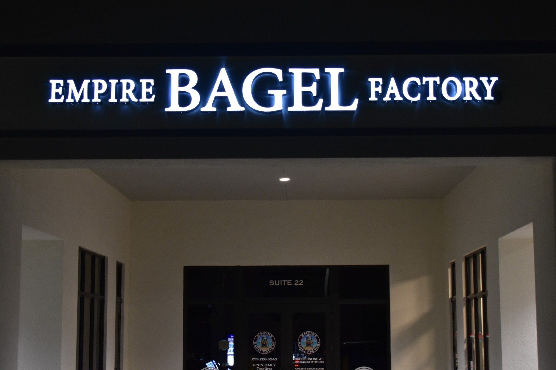 A sign for empire bagel factory is lit up at night