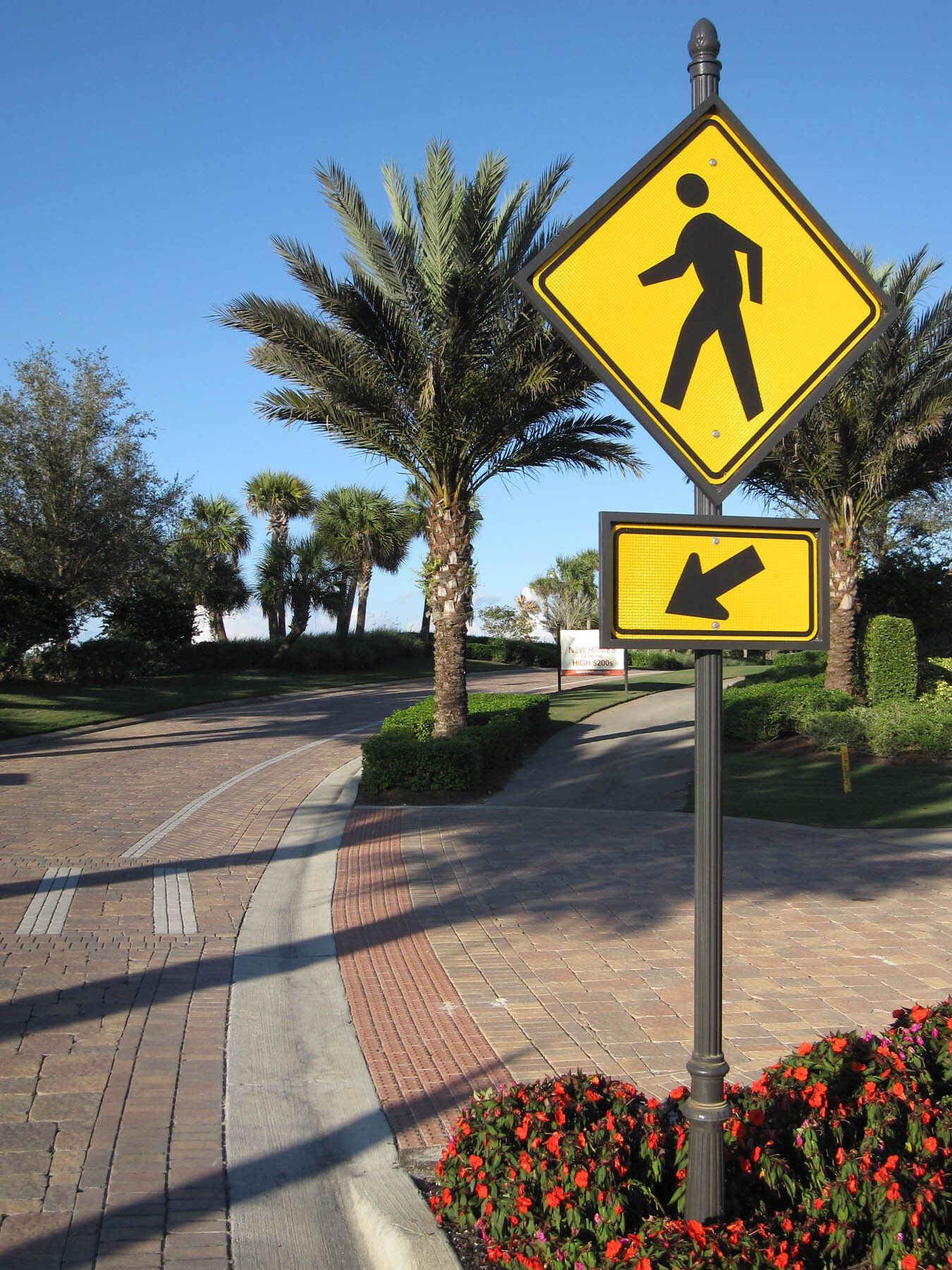 A pedestrian crossing sign with an arrow pointing to the right