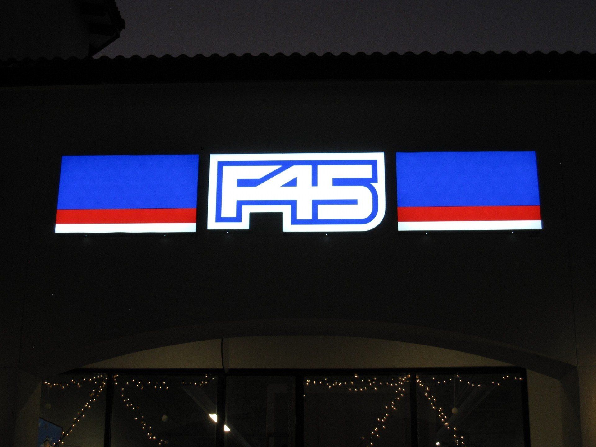 A sign for f45 is lit up at night