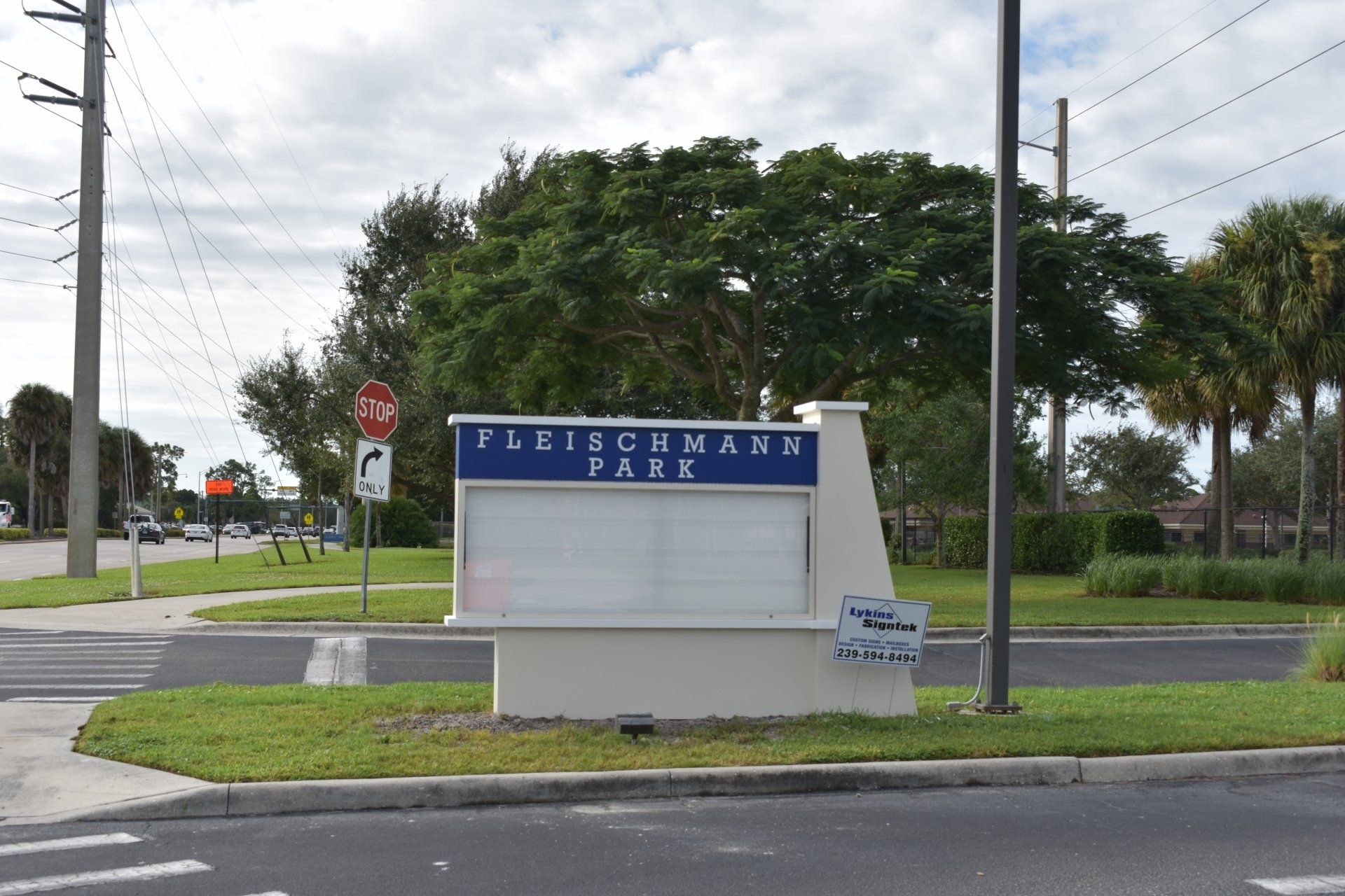 A sign for fleischmann park is on the side of the road