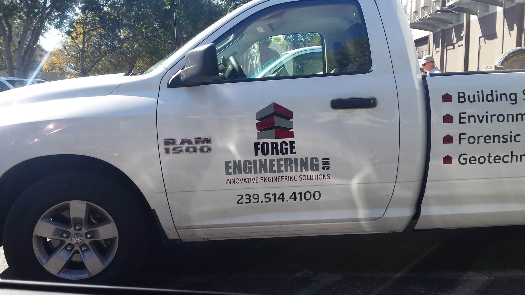 A white forge engineering truck is parked on the side of the road
