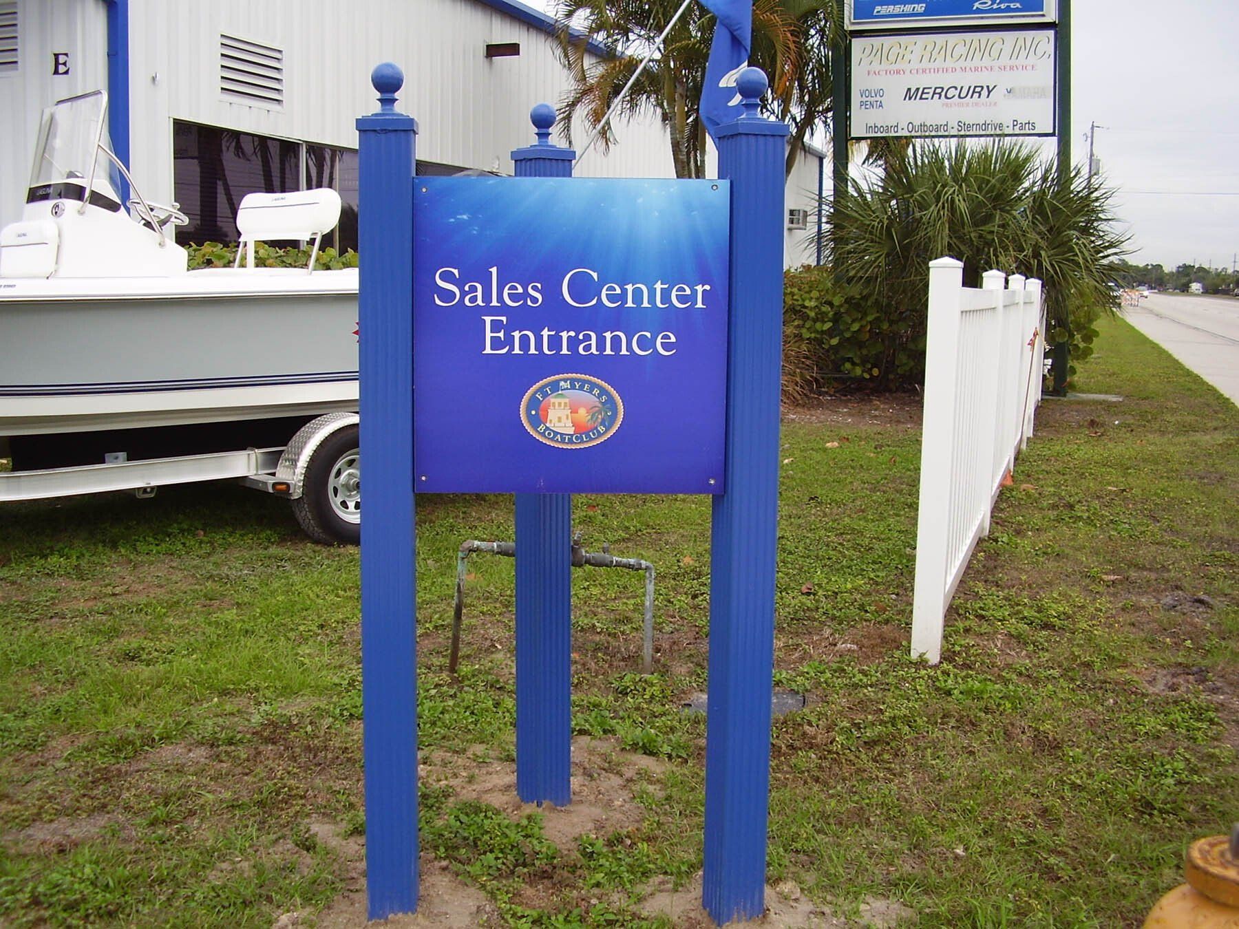 A blue sign that says sales center entrance on it