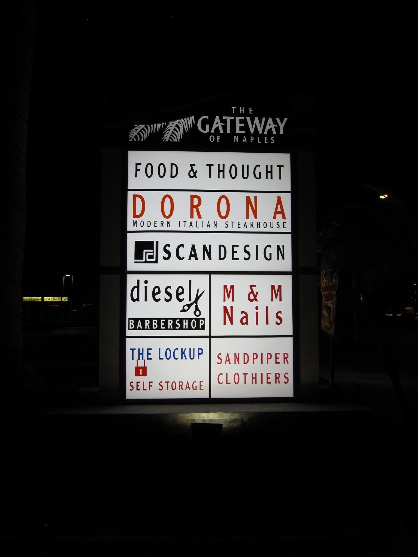 A sign for food and thought is lit up at night