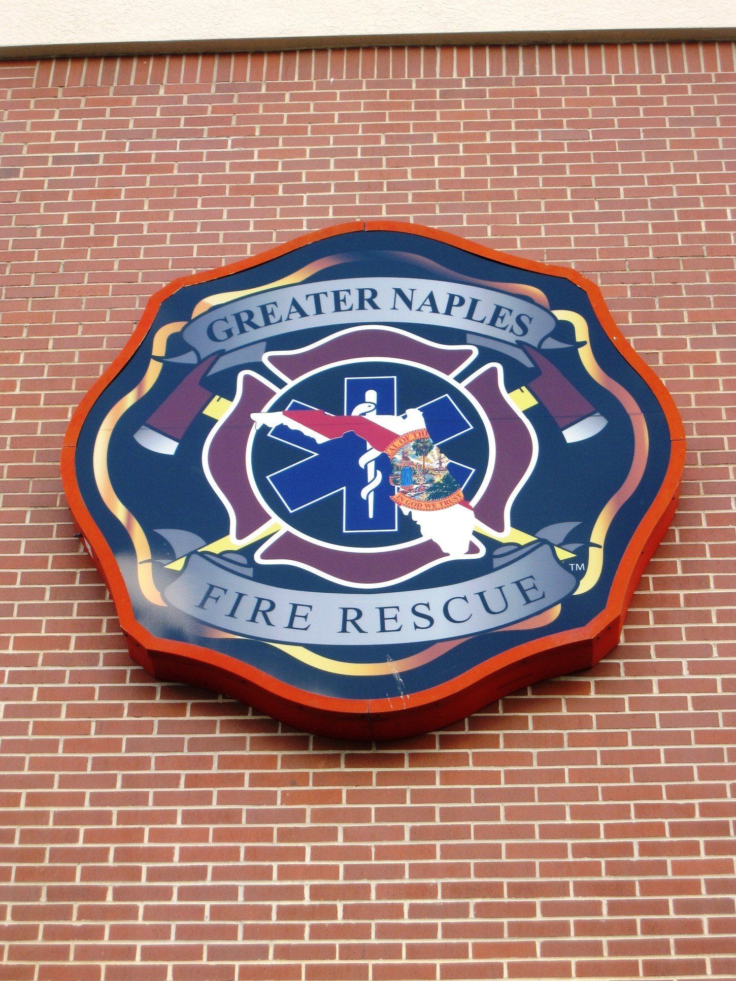 A greater naples fire rescue logo on a brick wall