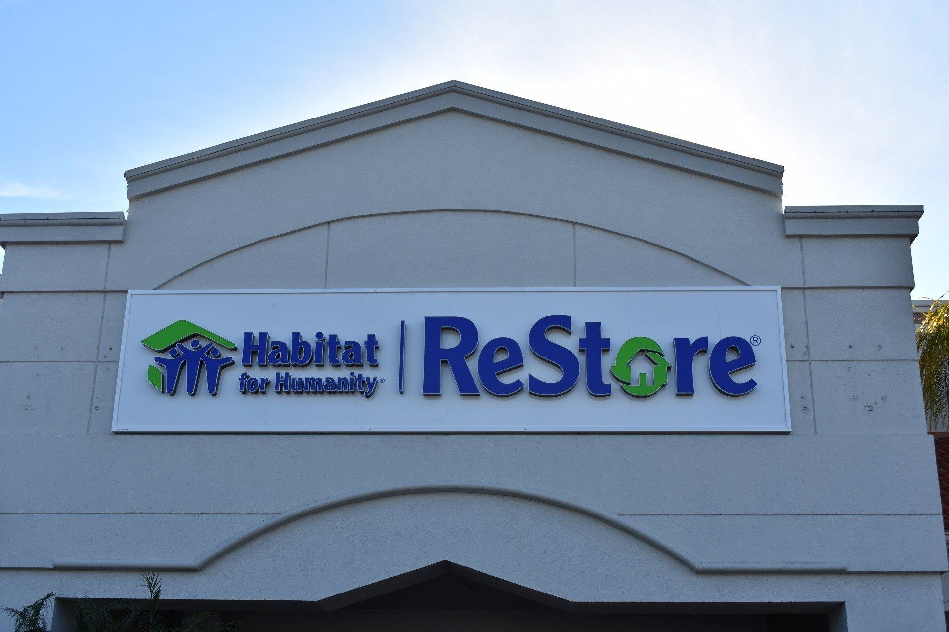 A sign on the side of a building that says habitat restore