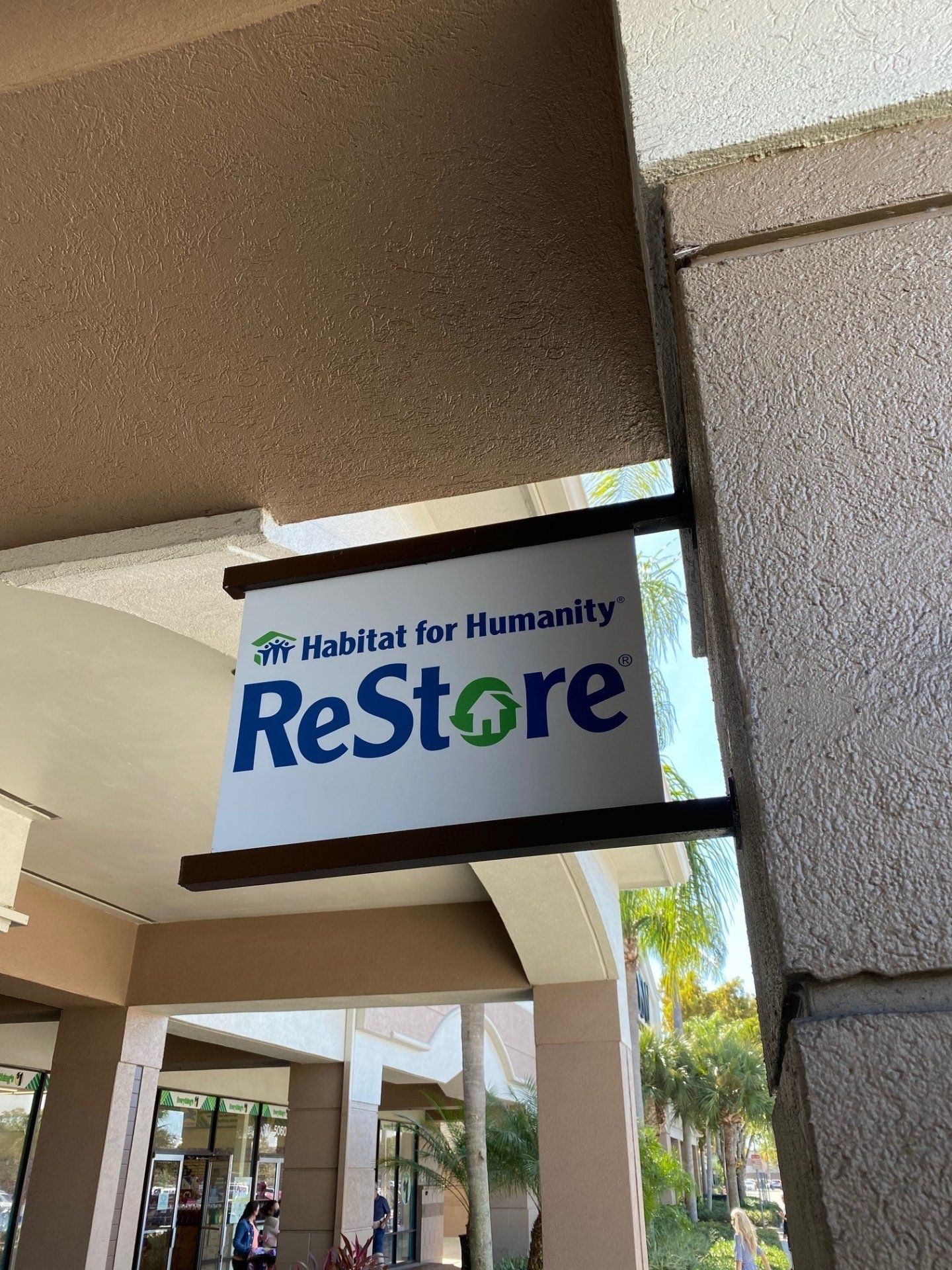A restore sign is hanging from the side of a building.