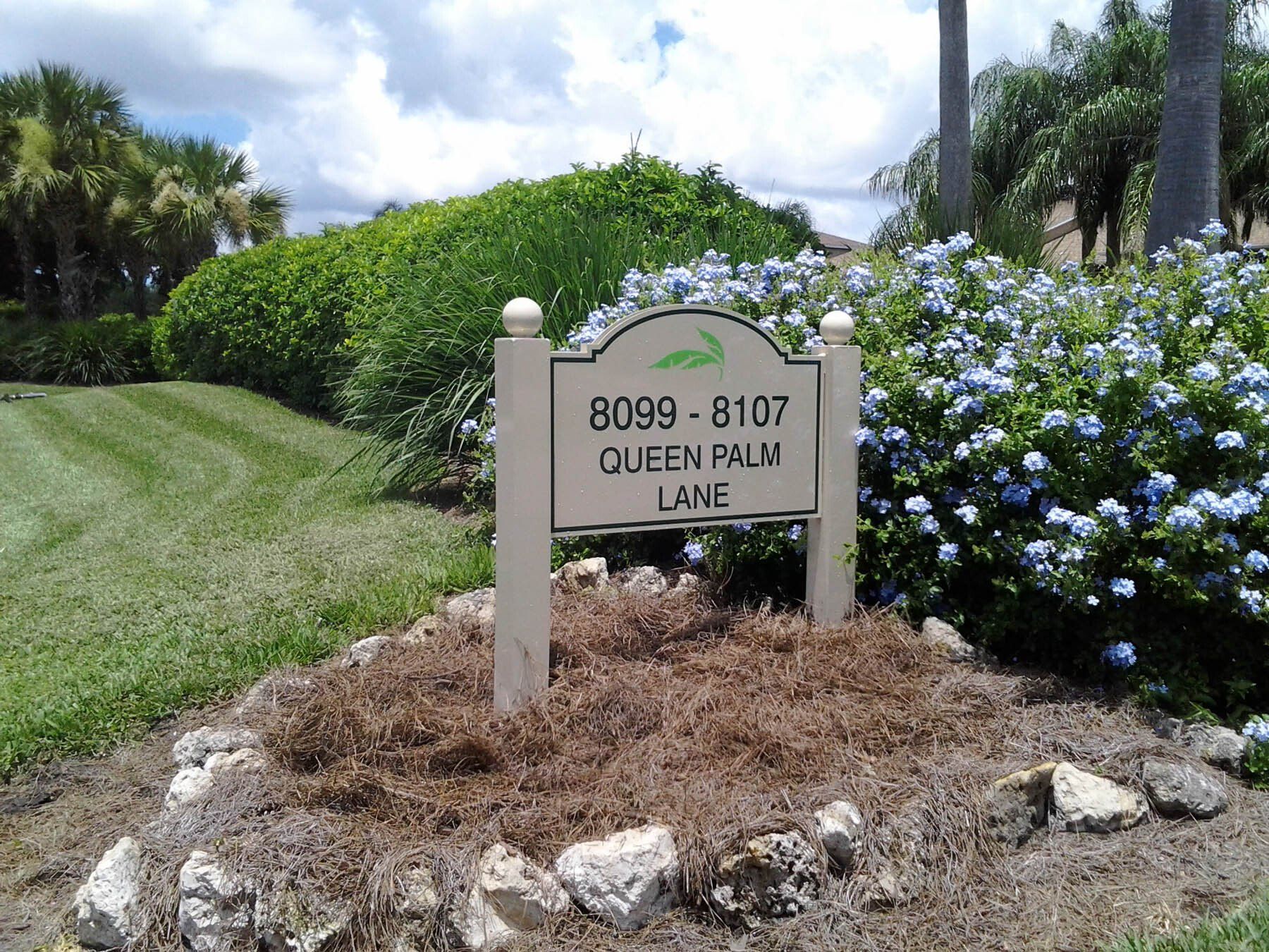 A sign that says queen palm lane on it