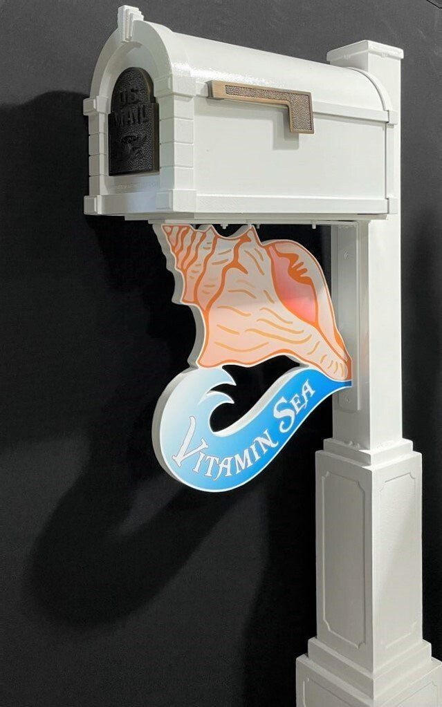 A white mailbox with a seashell on it