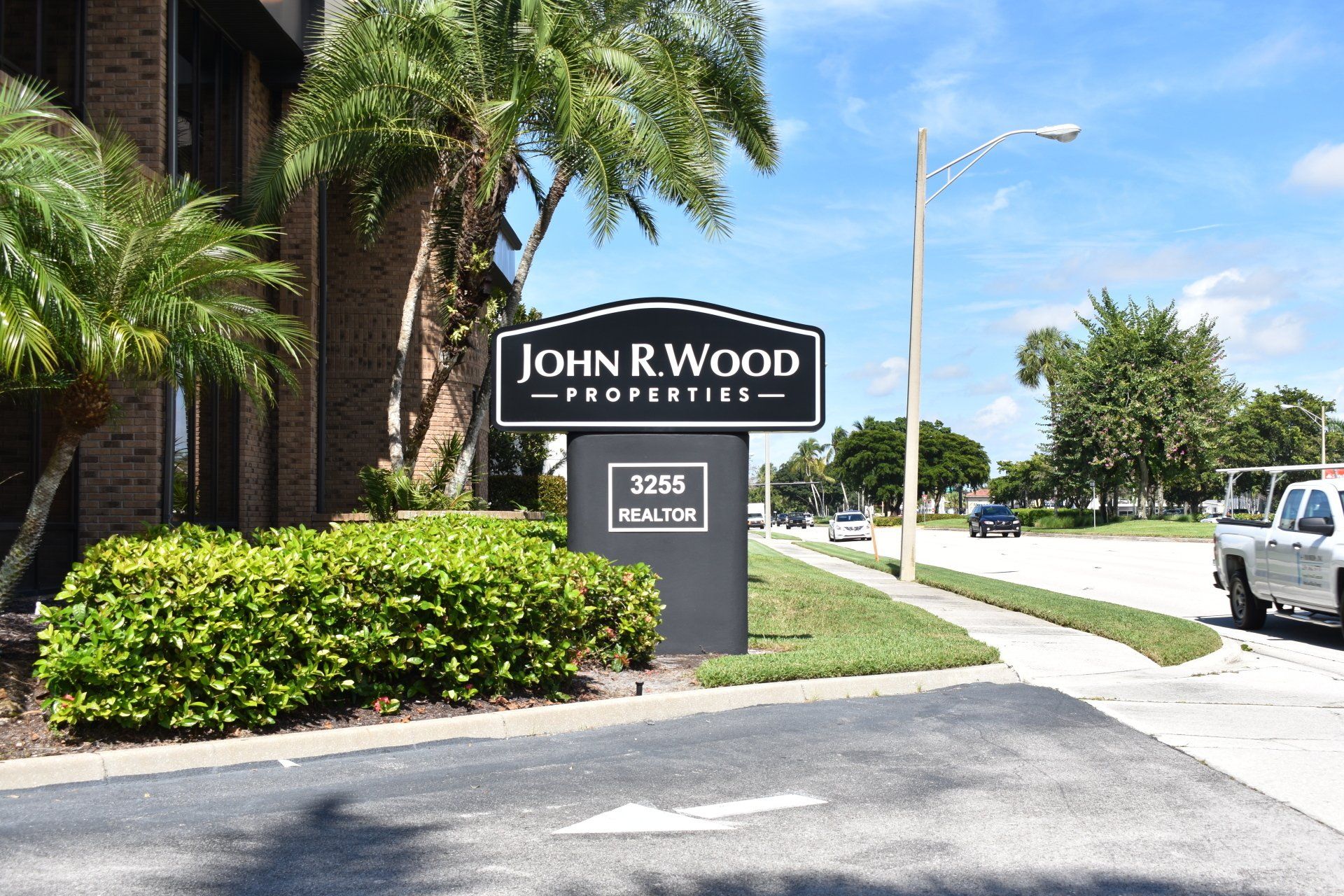 A sign for john r wood properties is in front of a building