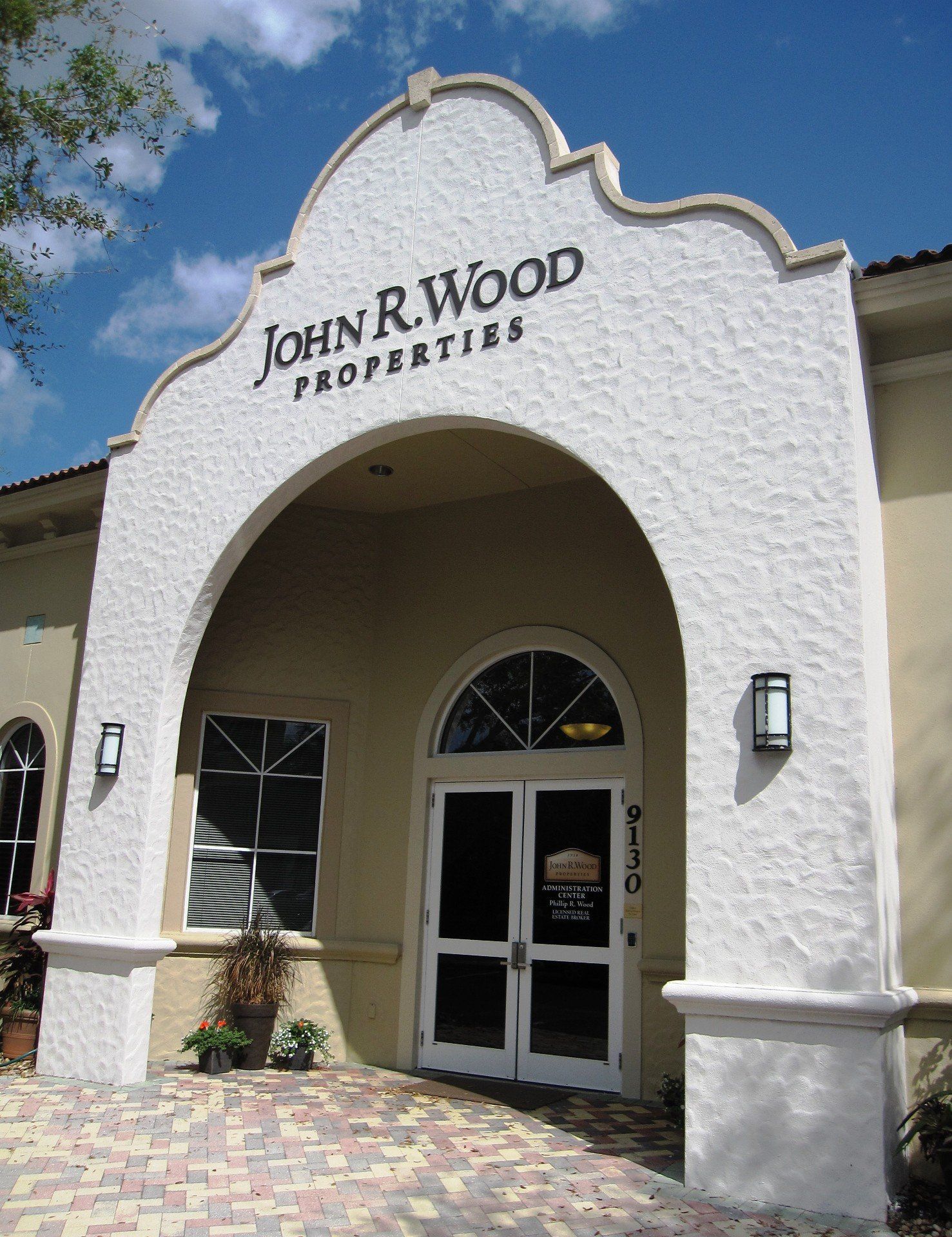 A white building with a sign that says john r wood properties