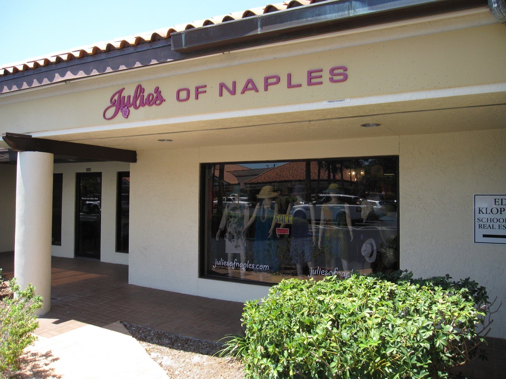 A white building with a sign that says ' ayle 's of naples ' on it