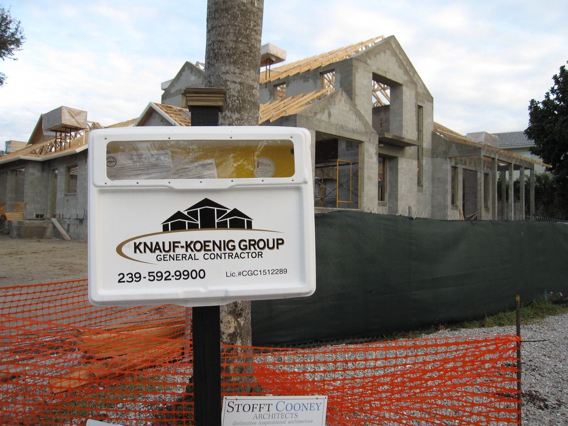 A sign for knauf koenig group is in front of a house under construction