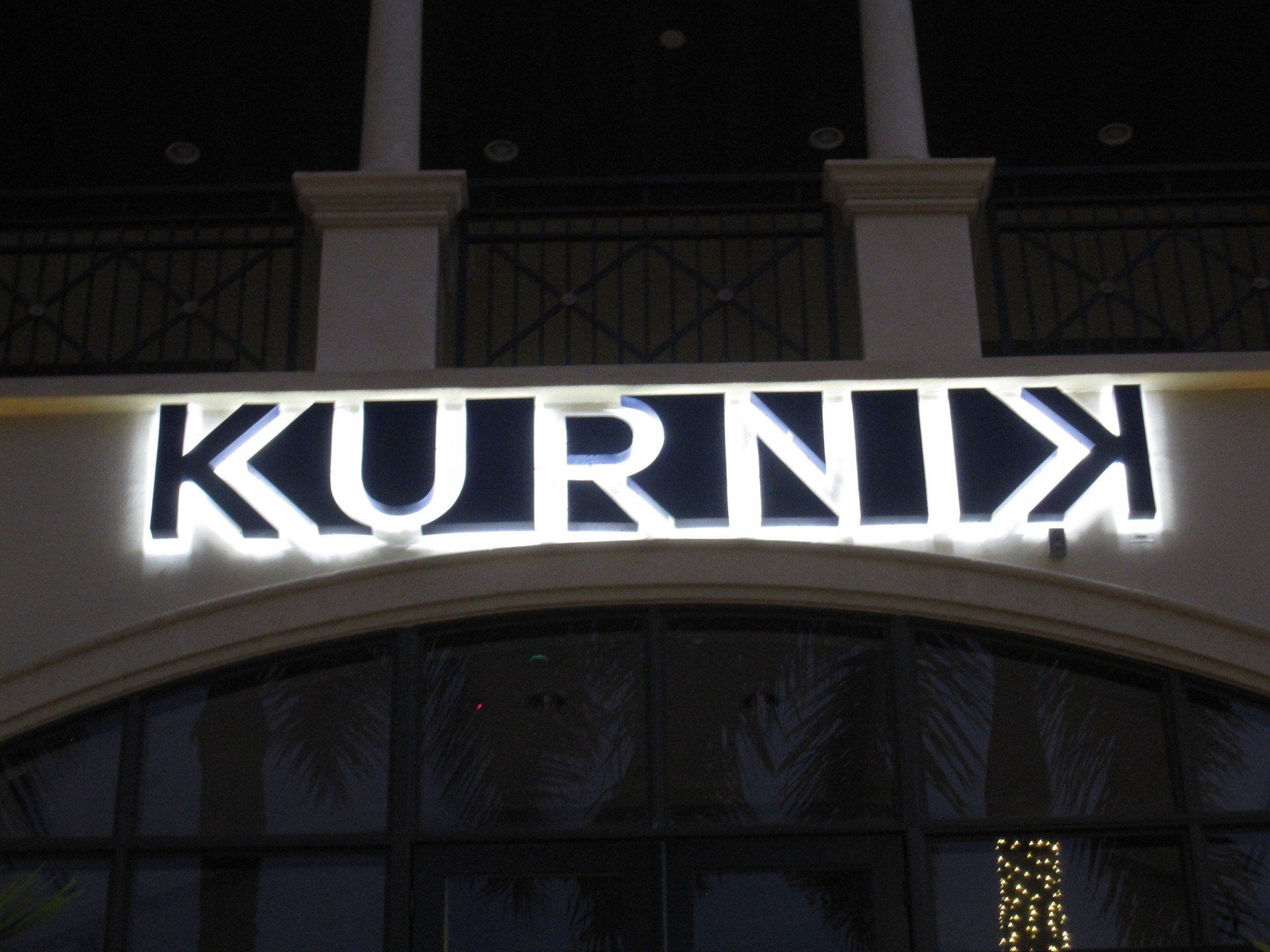 A sign for kurnix is lit up at night