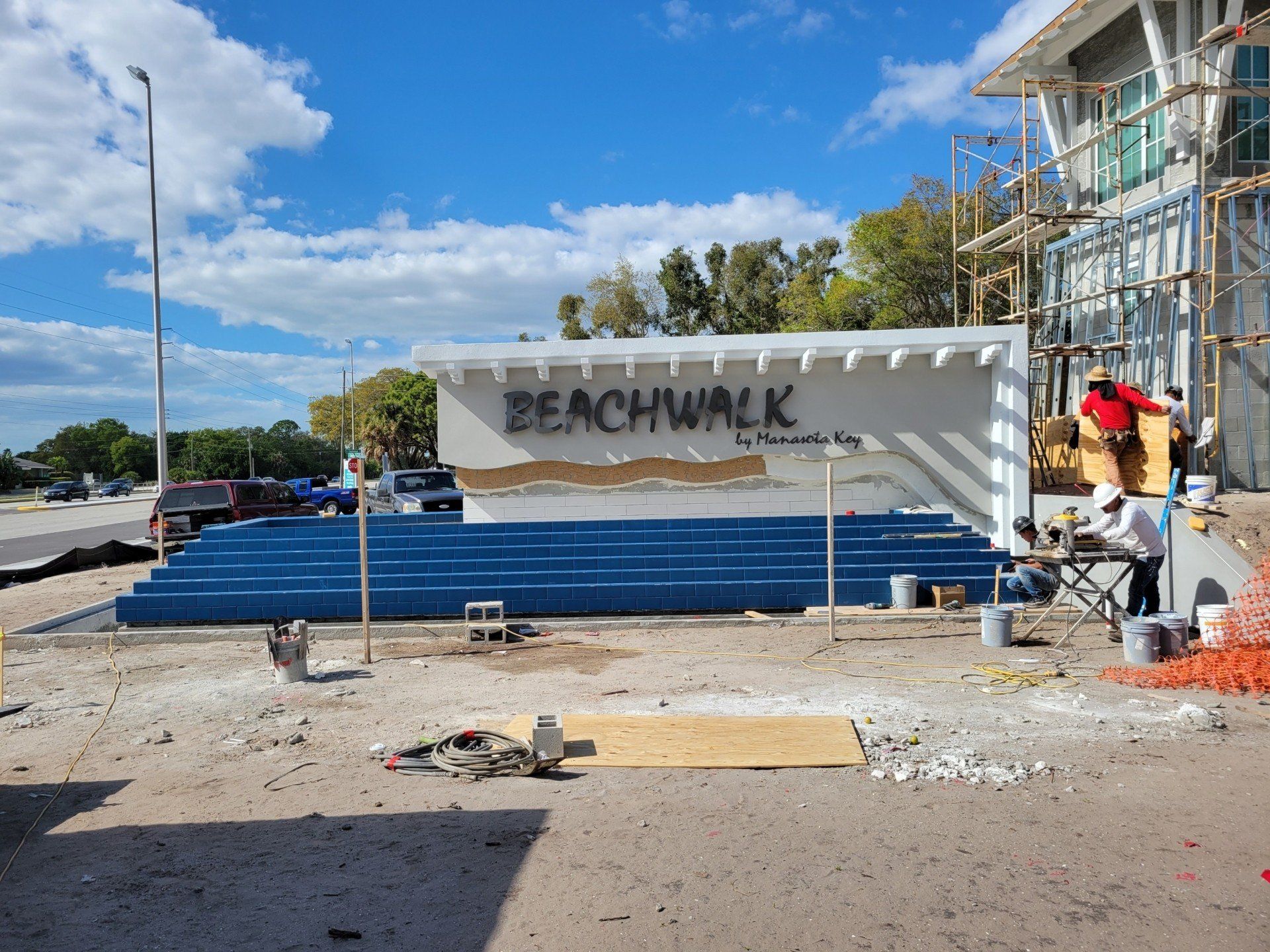 A beachwalk sign is being built in front of a building under construction.