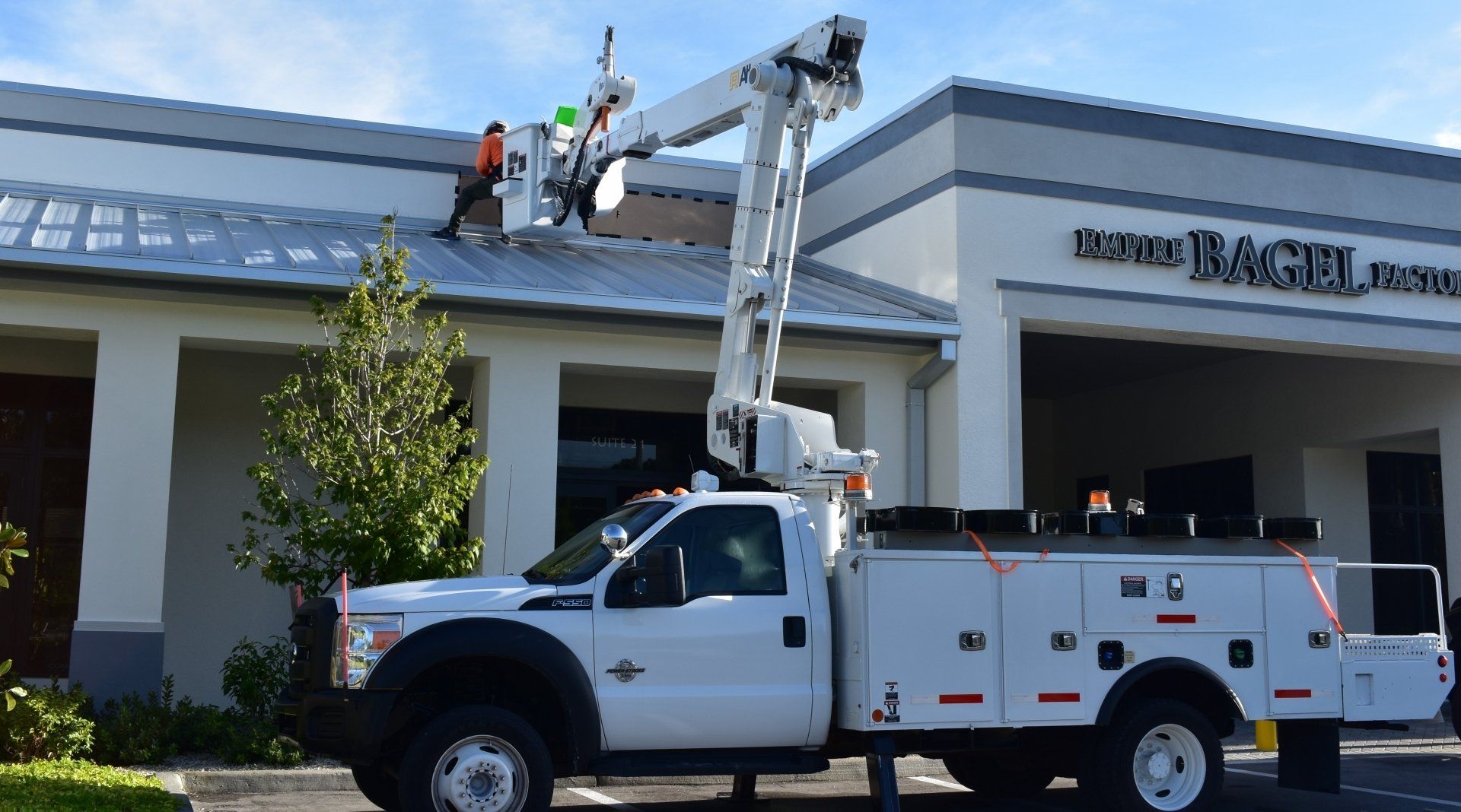 A white utility truck is parked in front of a building.