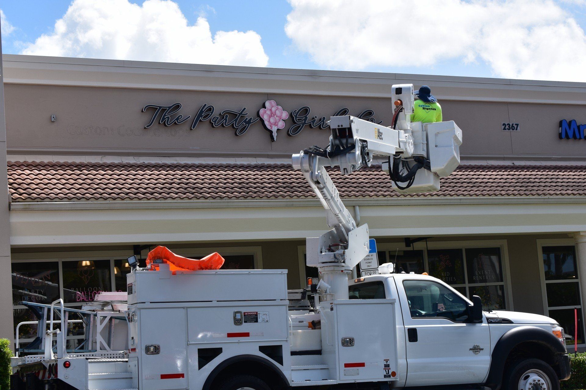 A white utility truck is parked in front of a store