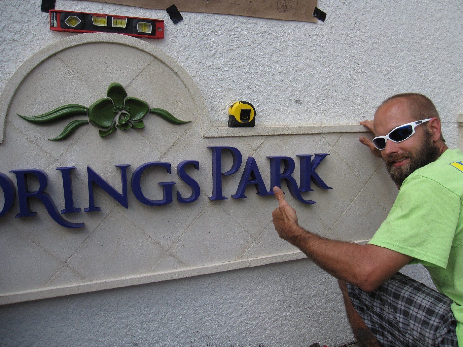 A man is kneeling in front of a sign that says springs park