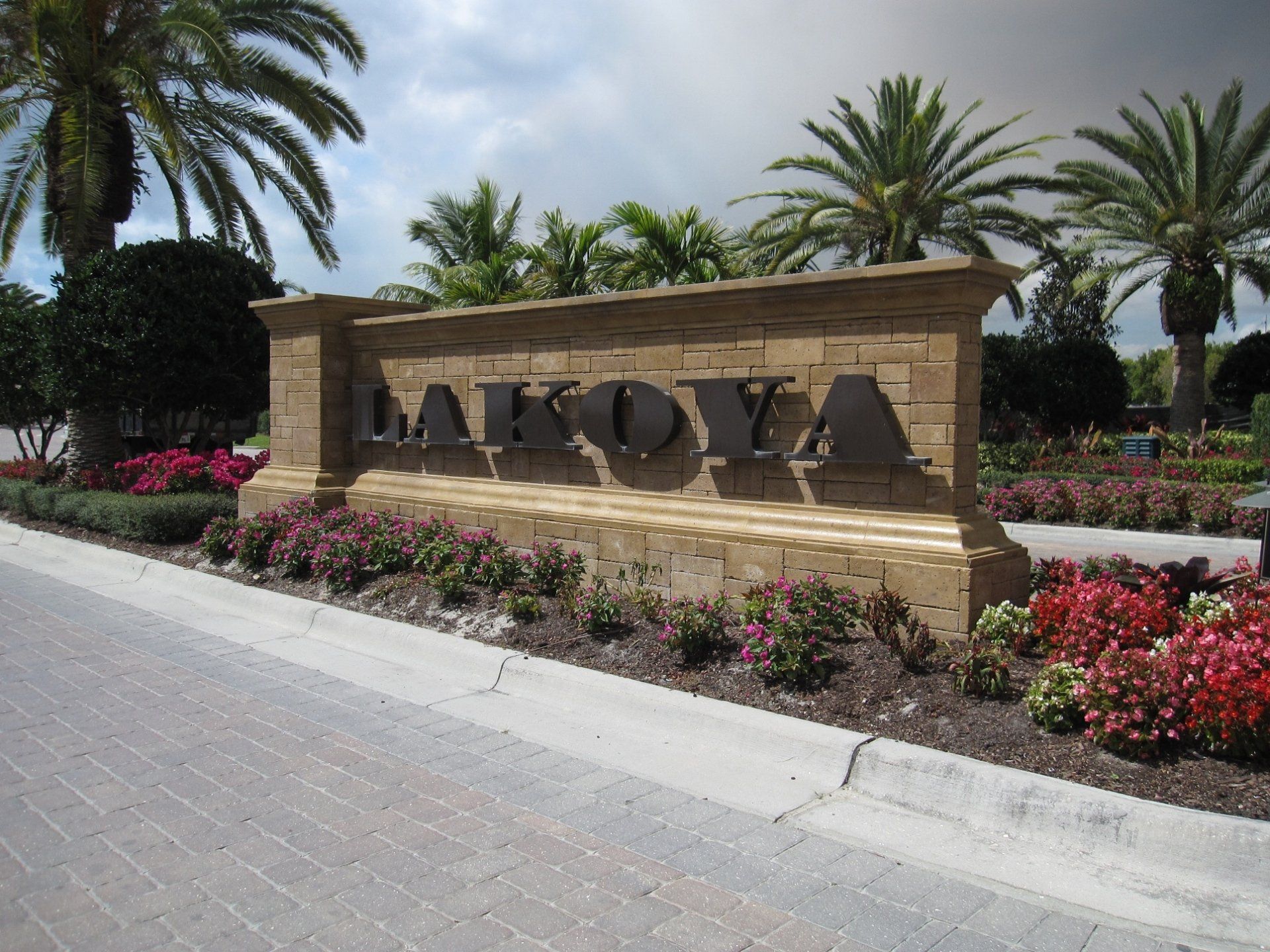 A sign that says lake oya is surrounded by palm trees