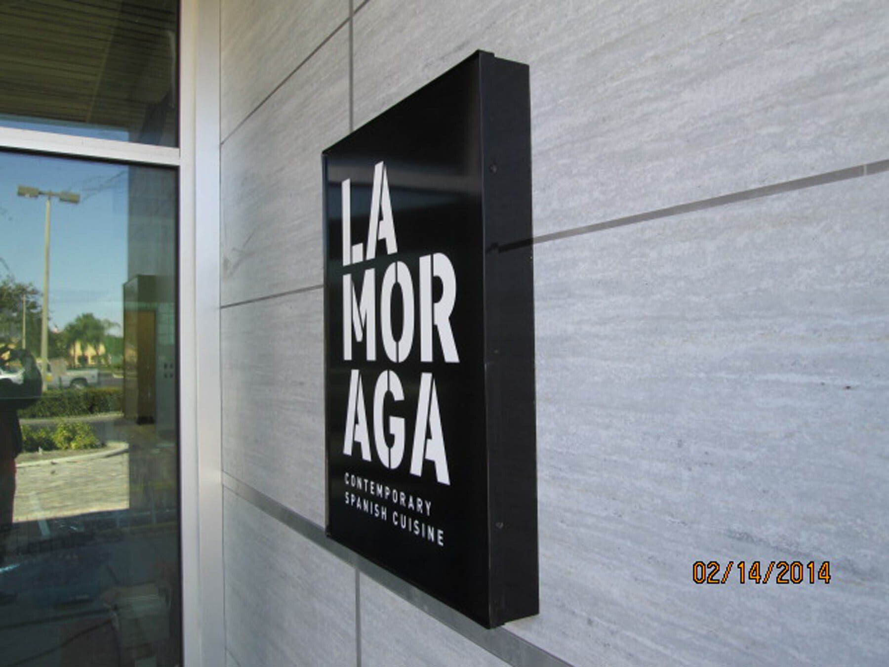 A sign on the side of a building that says la mor aga