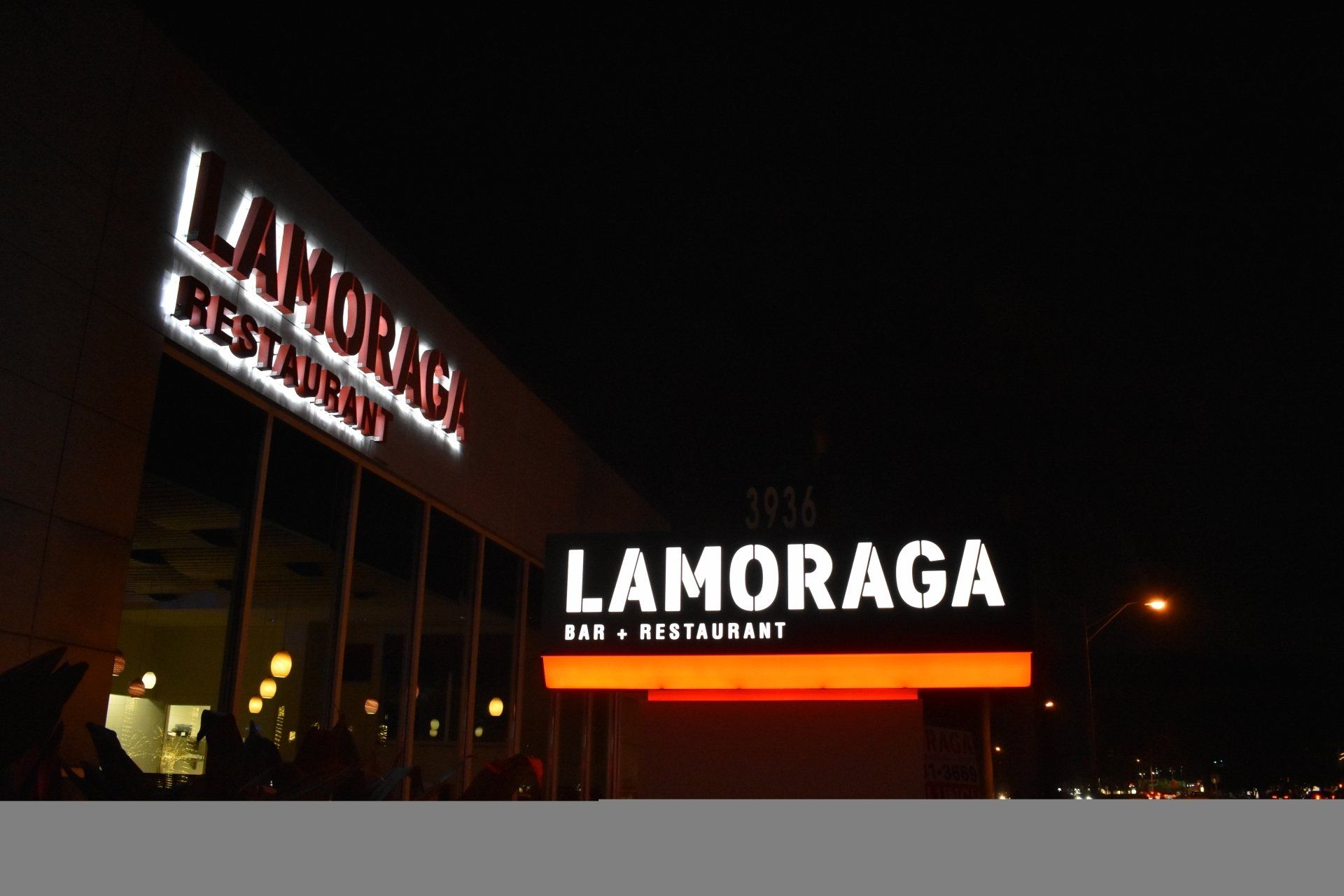 A restaurant called lamorada is lit up at night