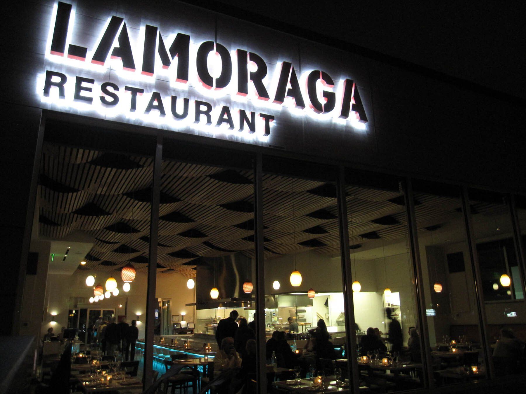 A restaurant called la moraga is lit up at night