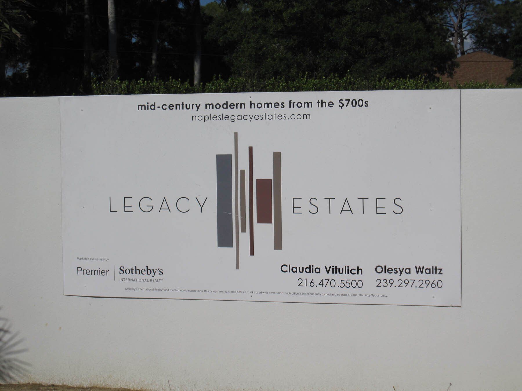 A sign for legacy estates is on a white wall
