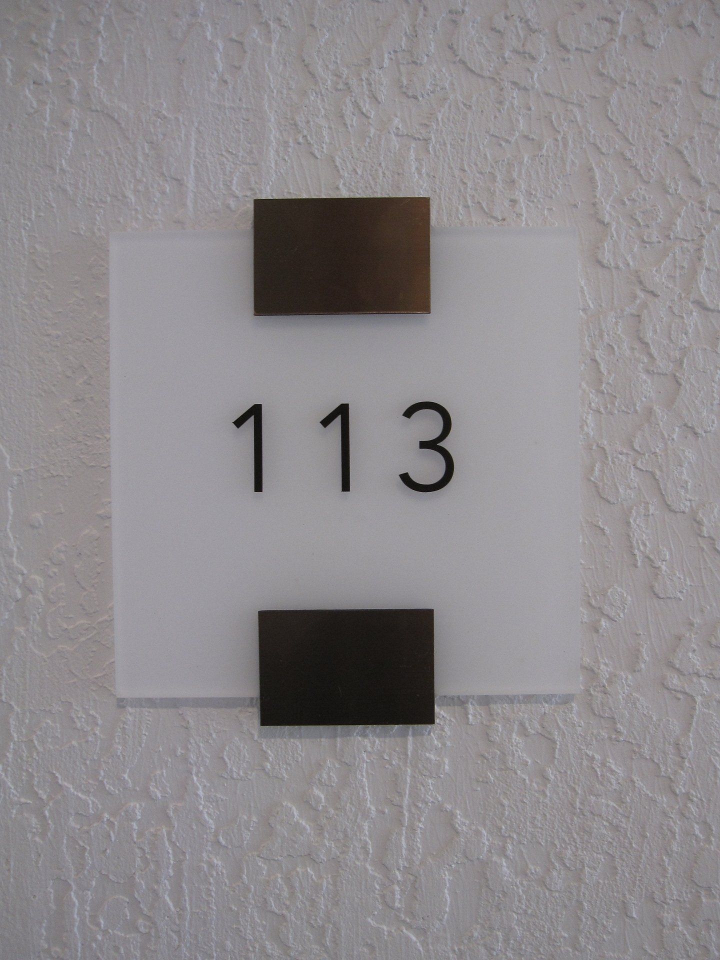 A sign on a wall that says 113 on it