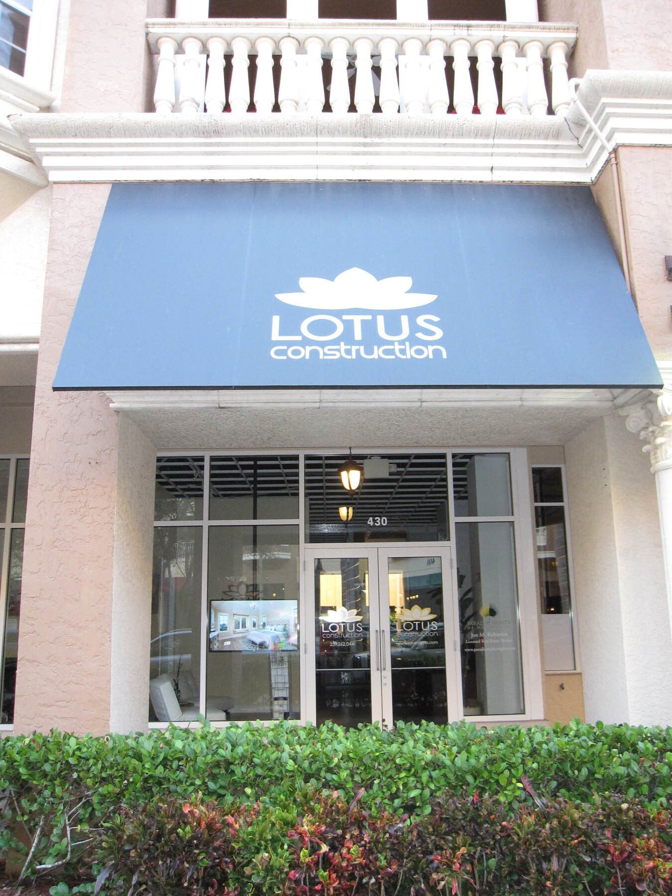 A building with a blue awning that says lotus construction