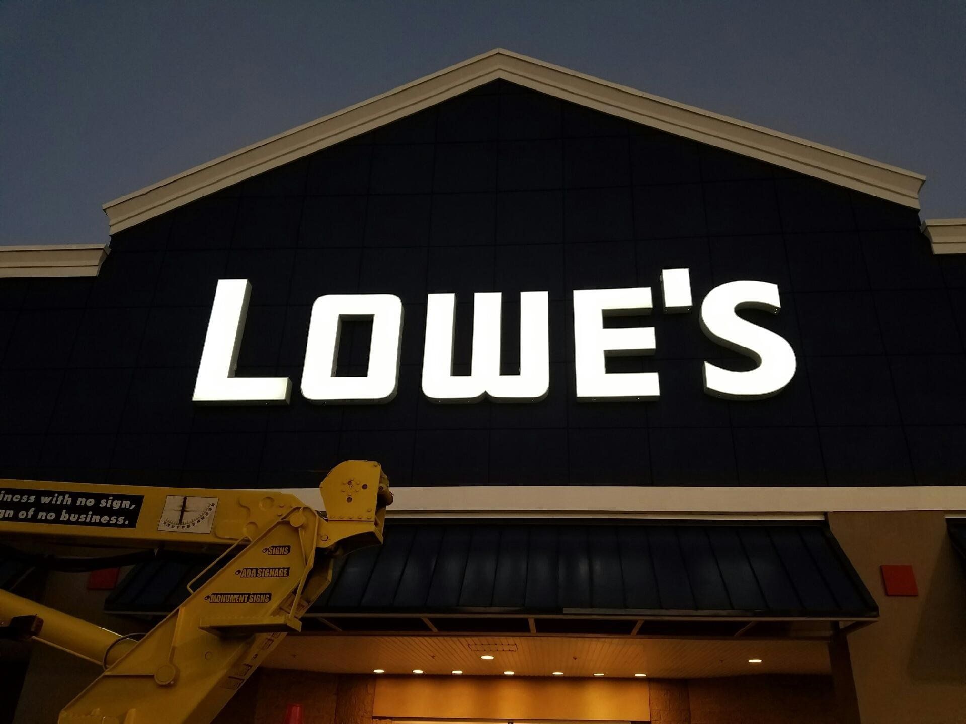 A large lowe 's sign is lit up at night