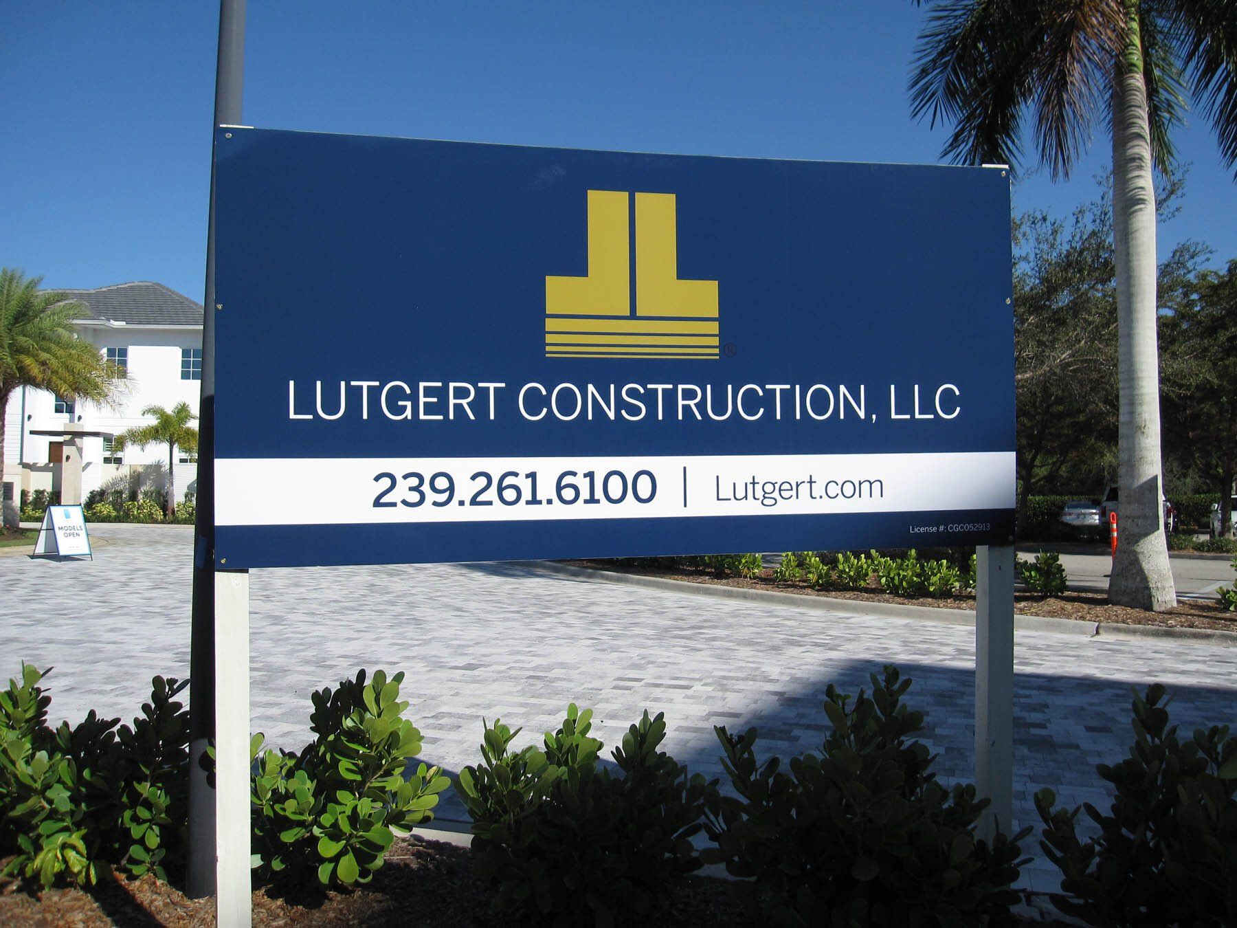 A blue and white sign for lutgert construction llc