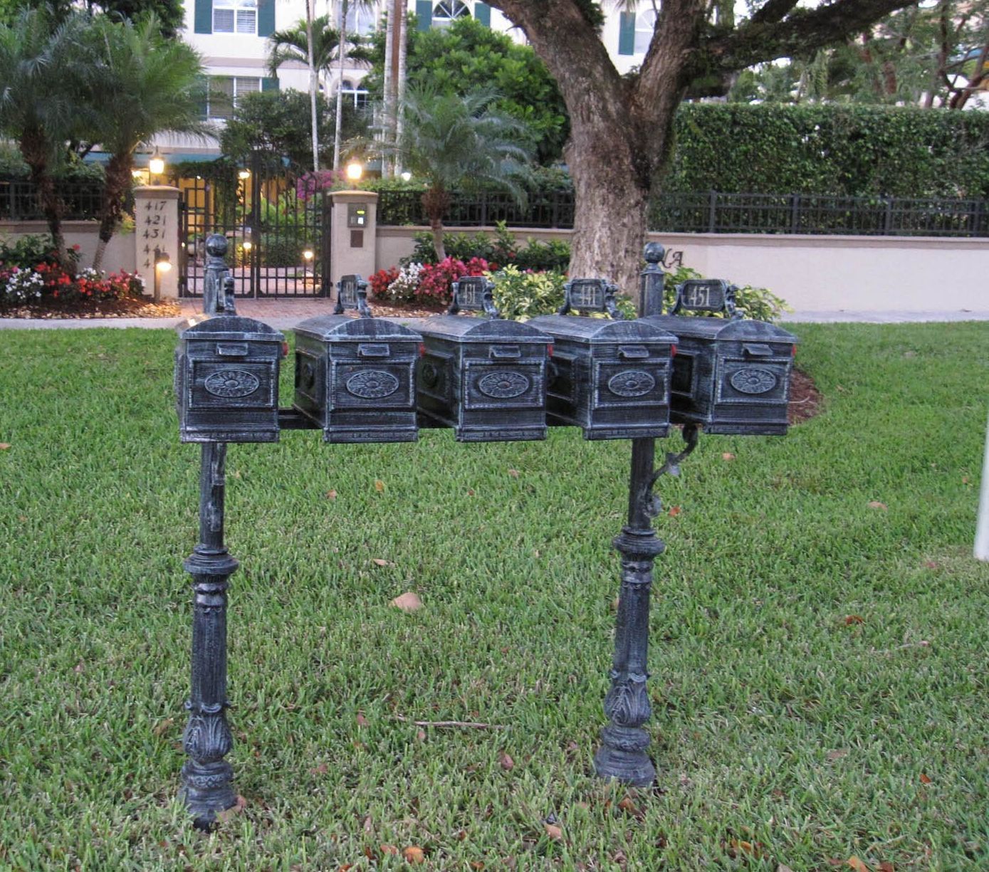 A row of mailboxes are lined up in a grassy yard