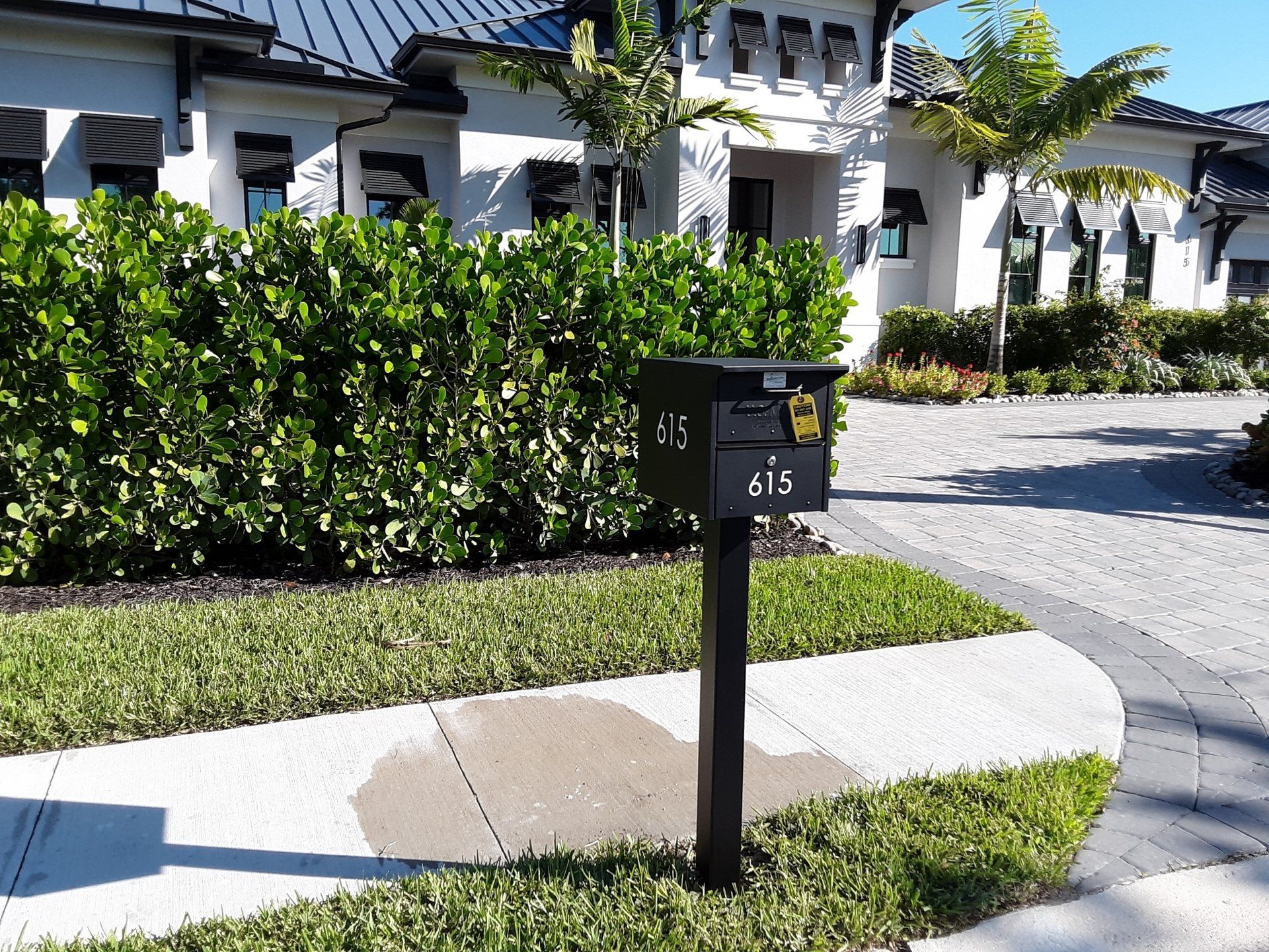 A black mailbox in front of a large white house