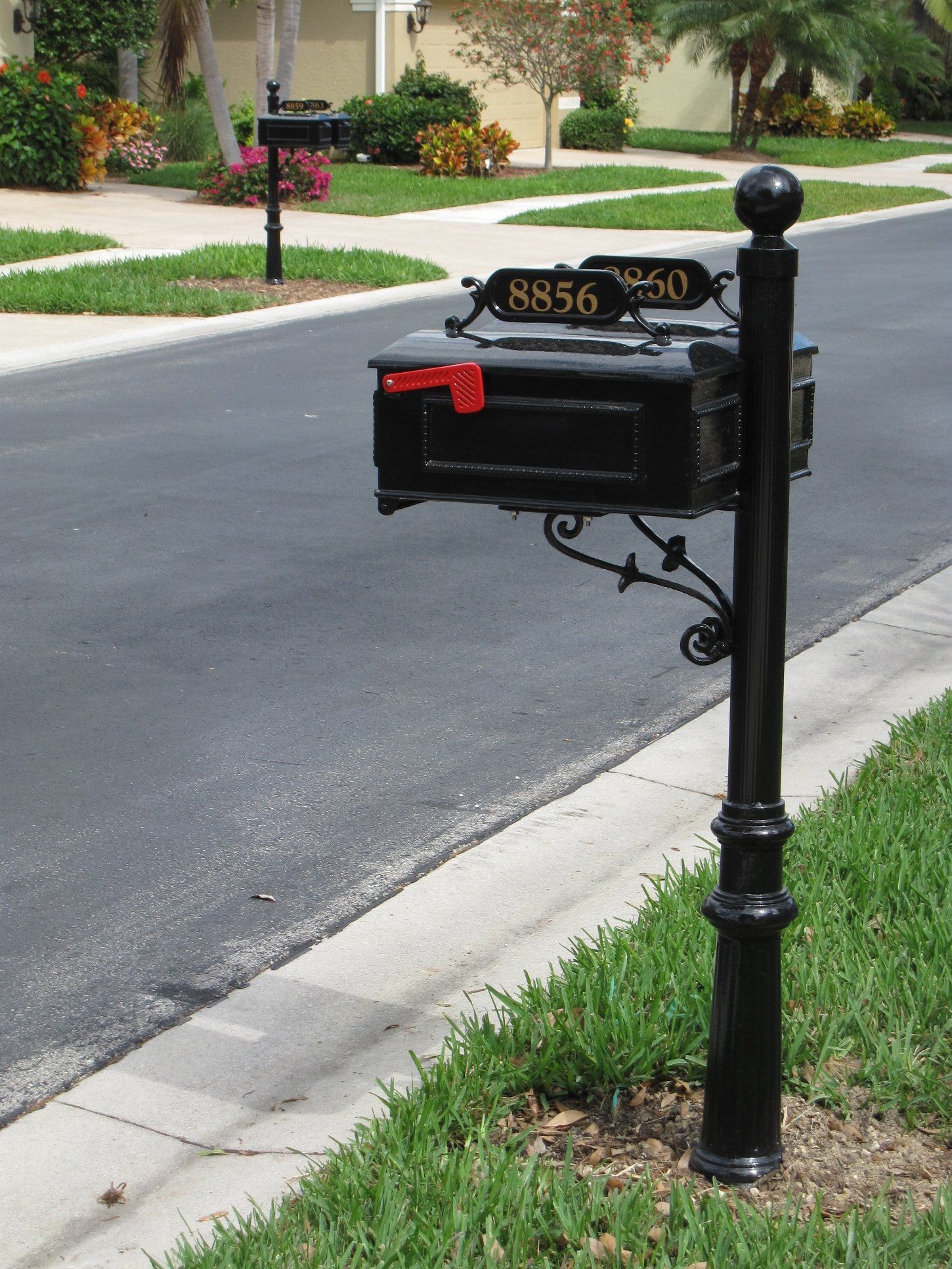 A black mailbox on the side of the road with the address 8956