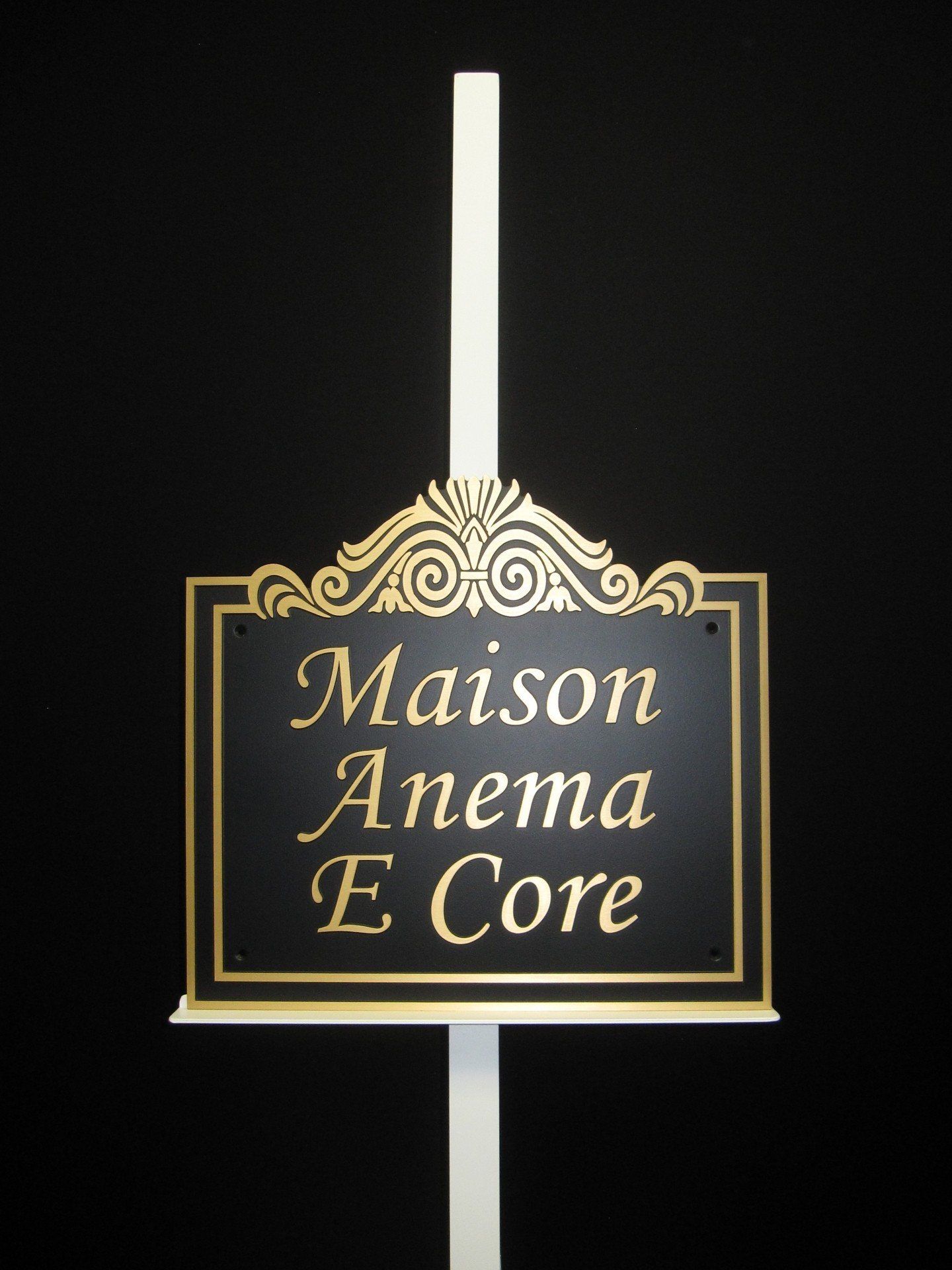 A black and gold sign that says maison anema e core