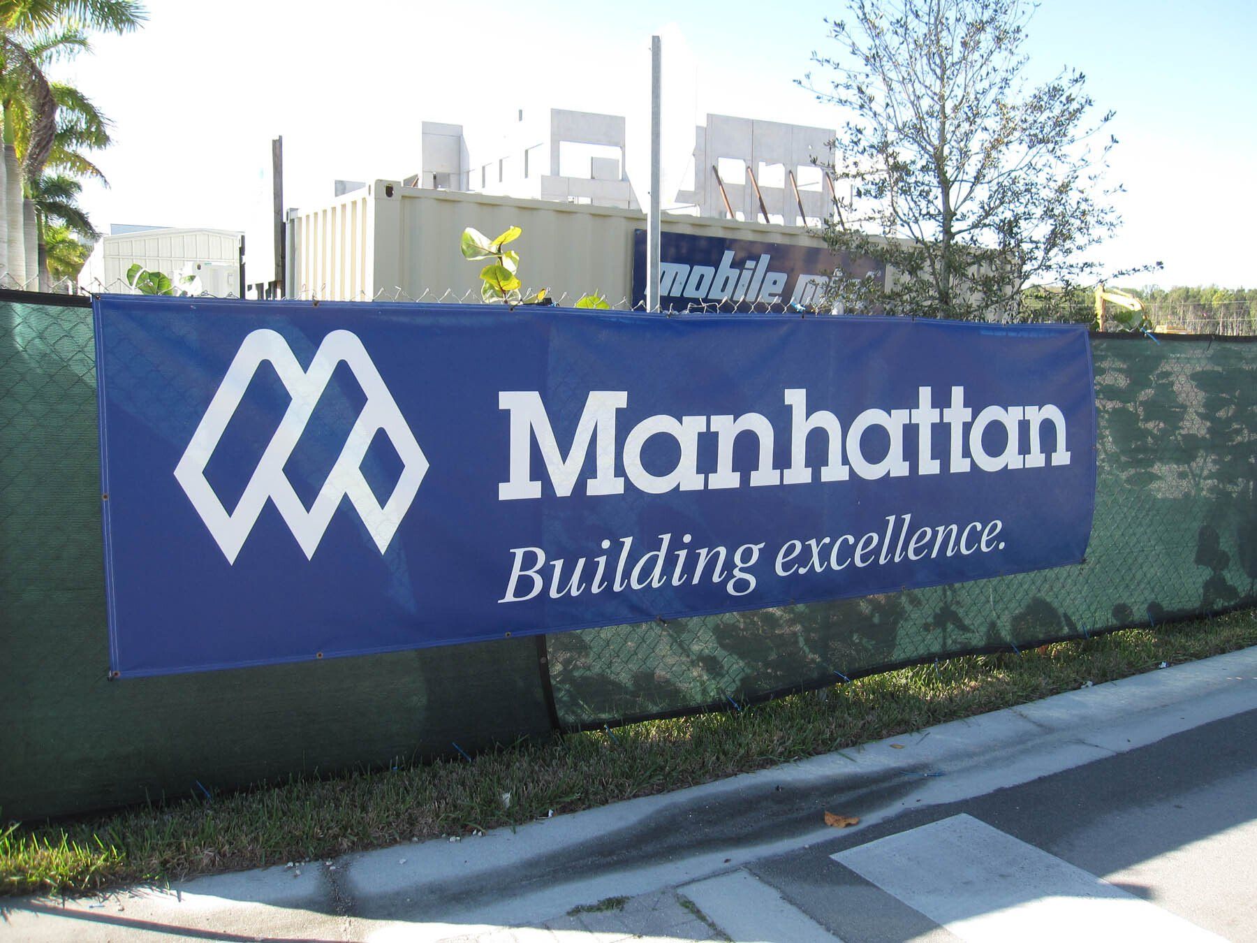 A manhattan building excellence banner hangs on a fence