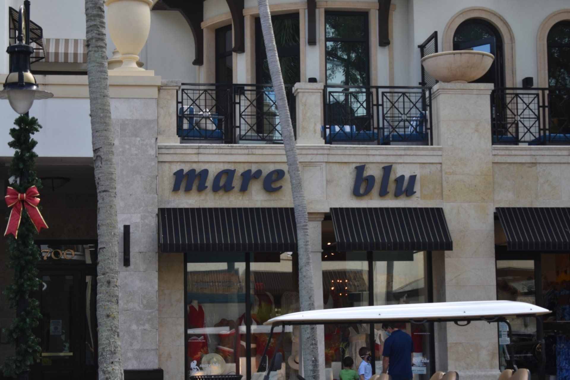 A store called mare blu has a golf cart parked in front of it