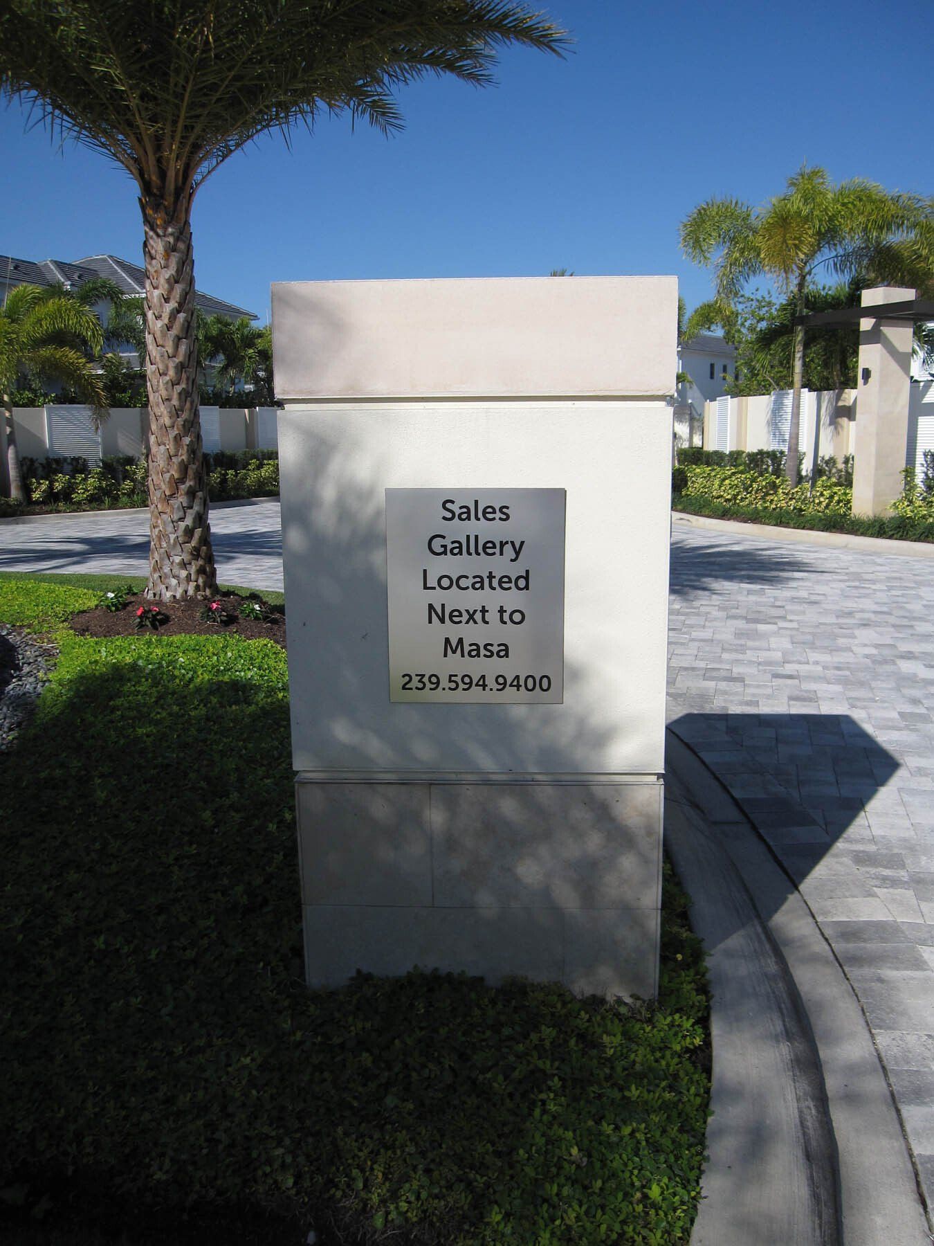 A sign that says sales gallery located next to plaza
