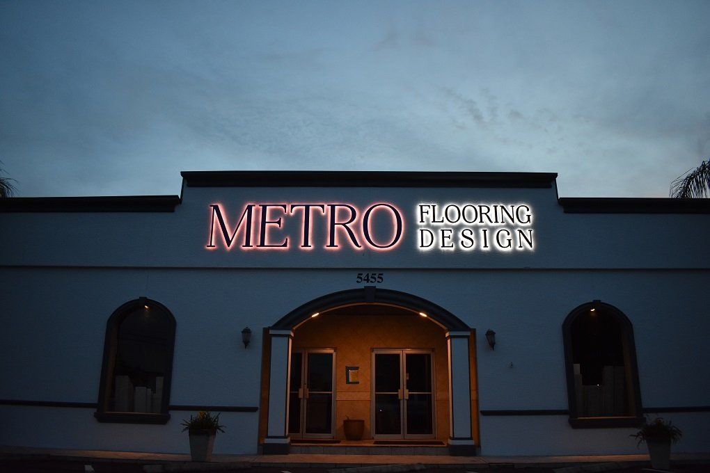 A building with a neon sign that says metro flooring design