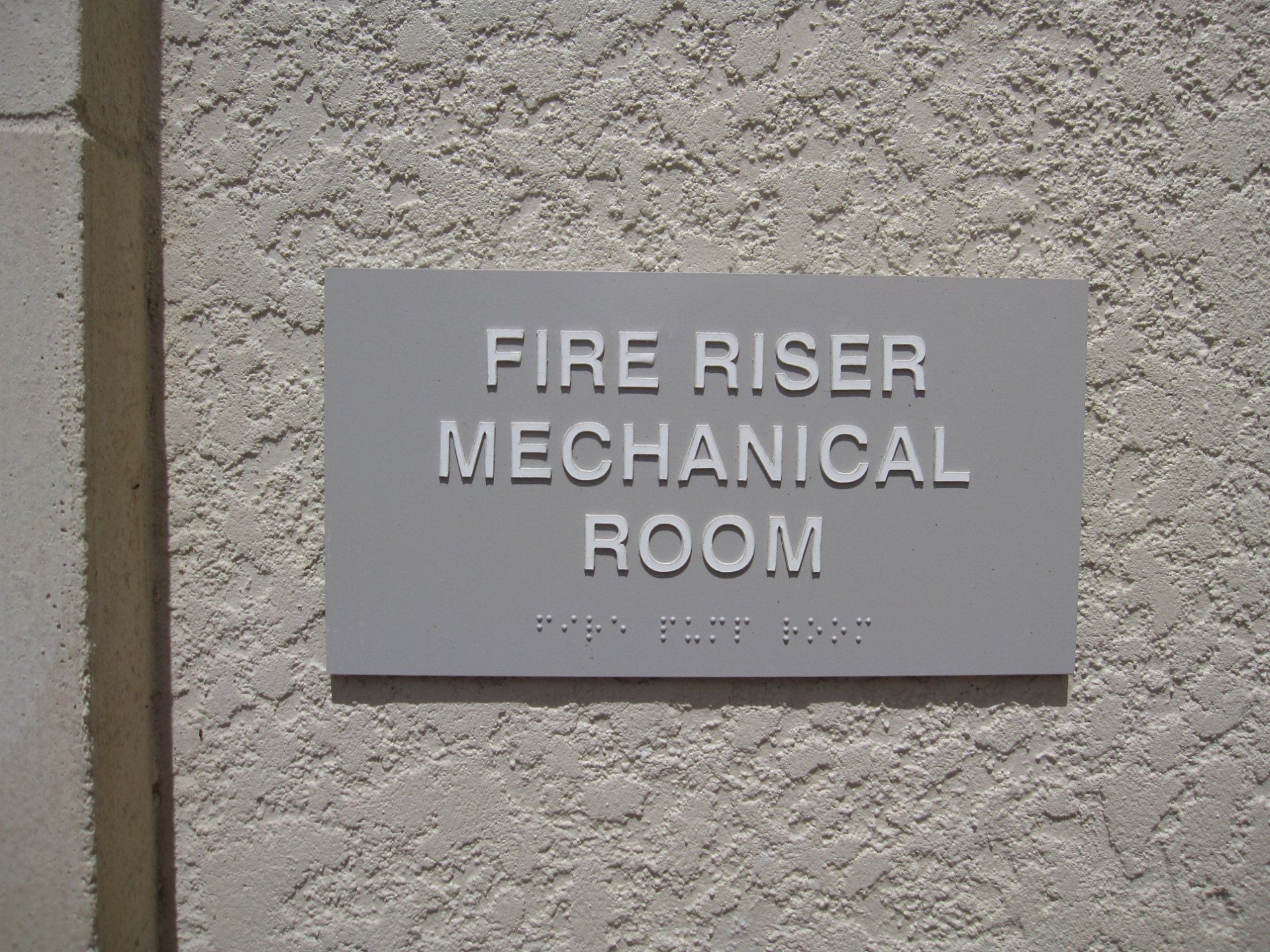 A sign on a wall that says fire riser mechanical room