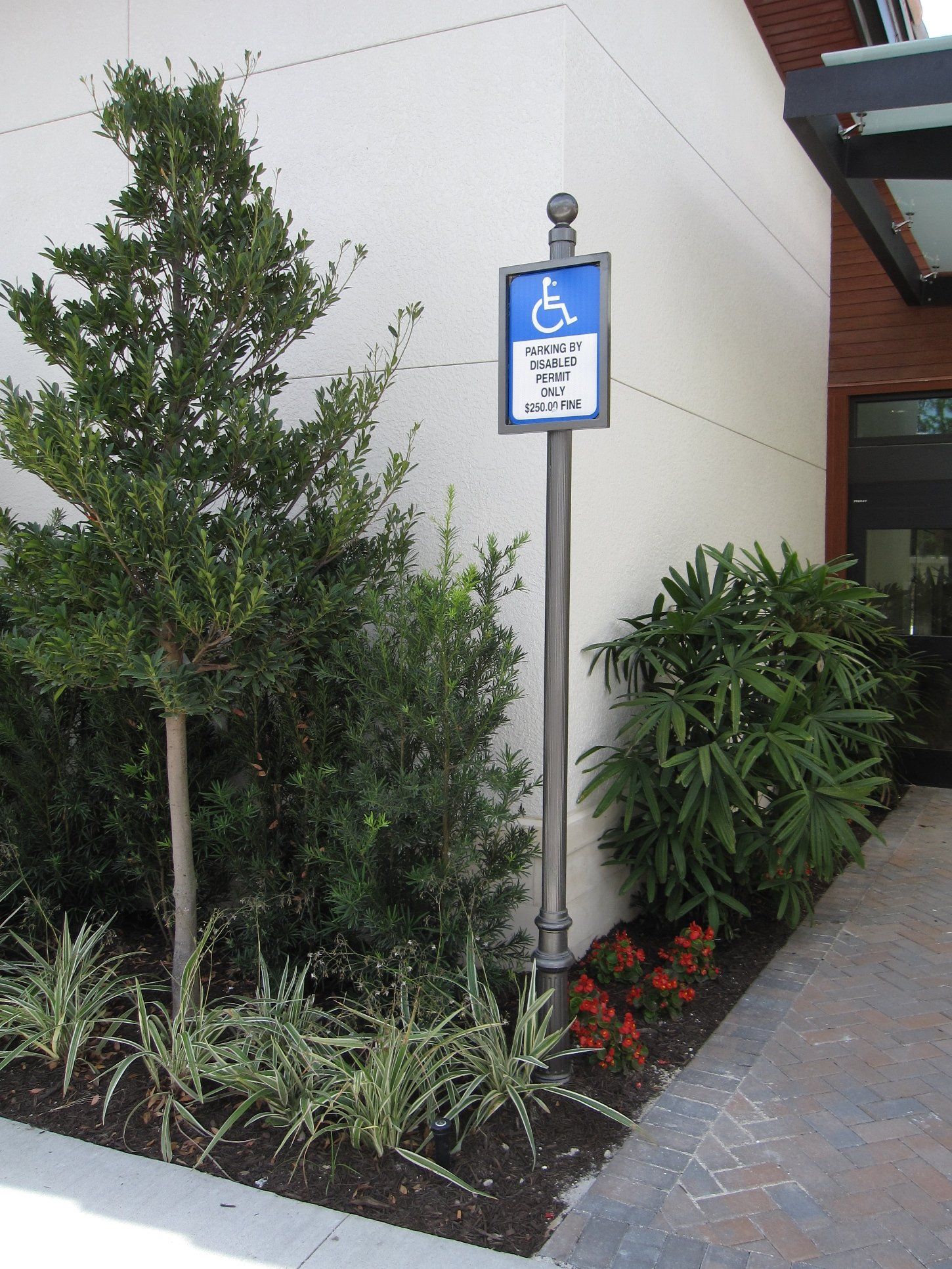 A handicapped parking sign in front of a building
