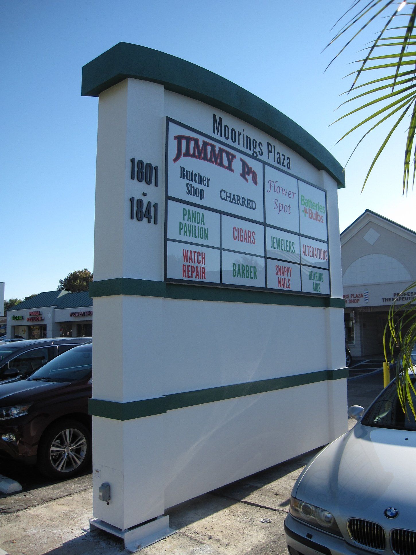 A sign for jimmy 's place sits in a parking lot