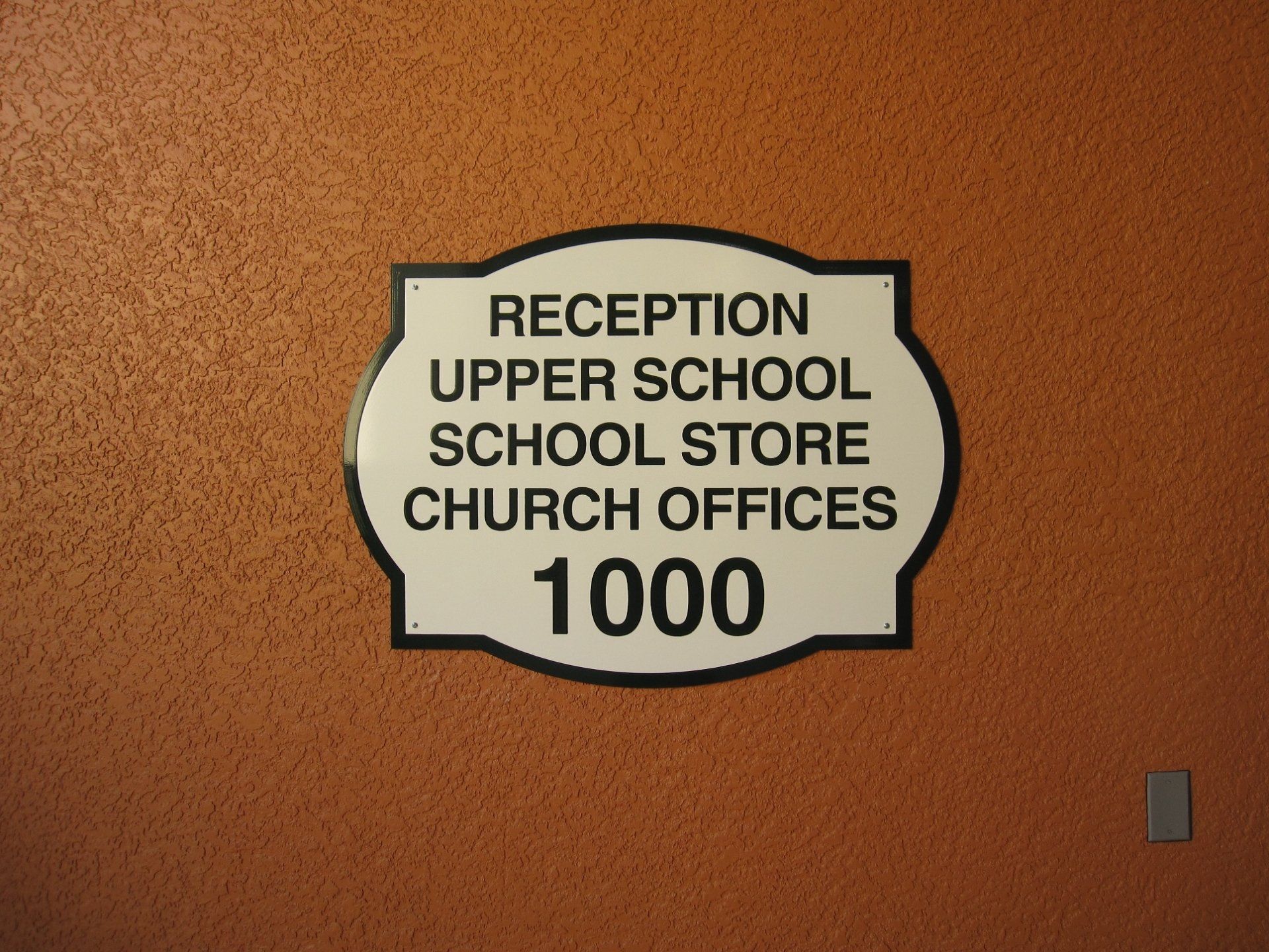 A sign that says reception upper school school store church offices 1000