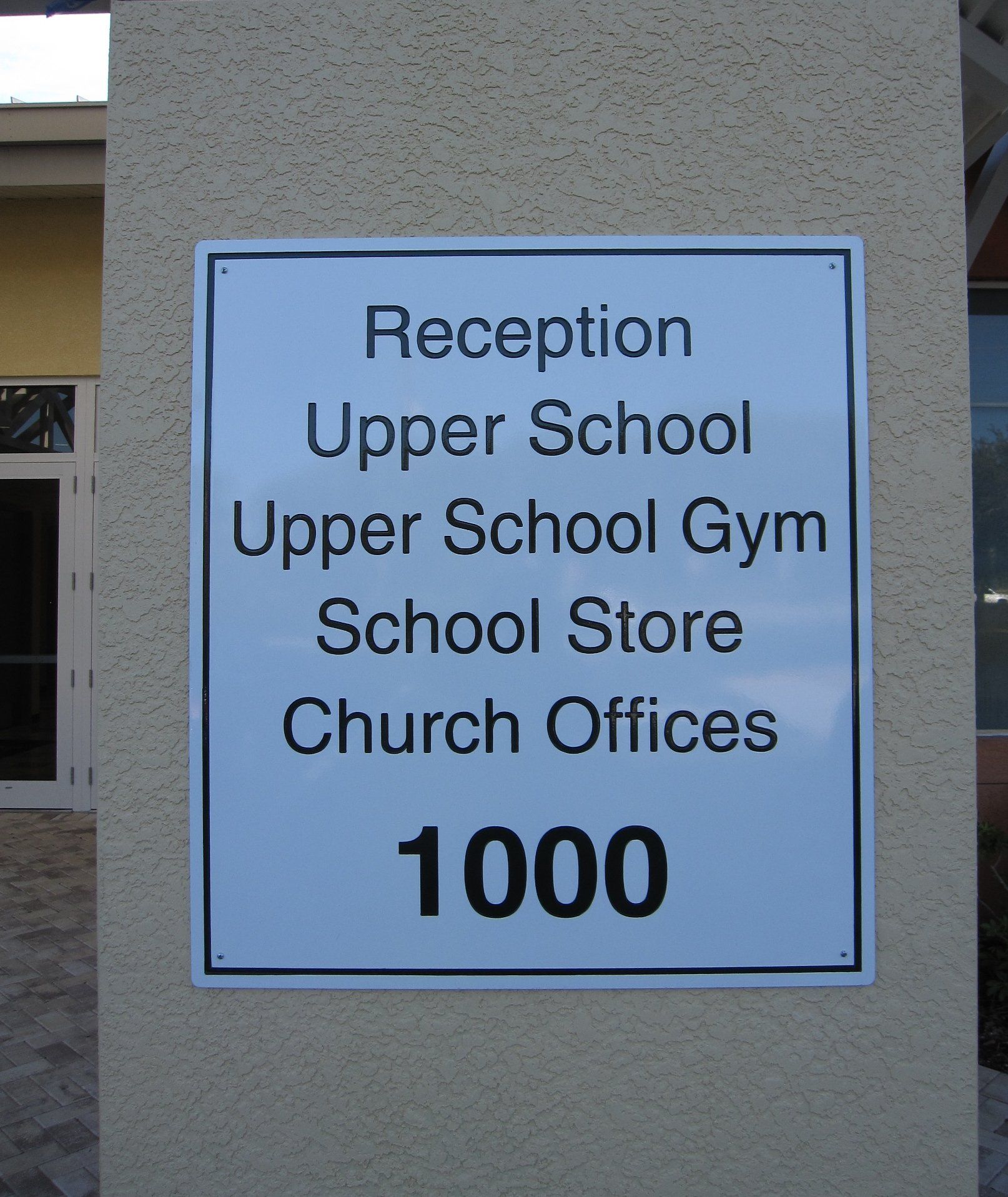 A sign that says reception upper school upper school gym school store church offices 1000